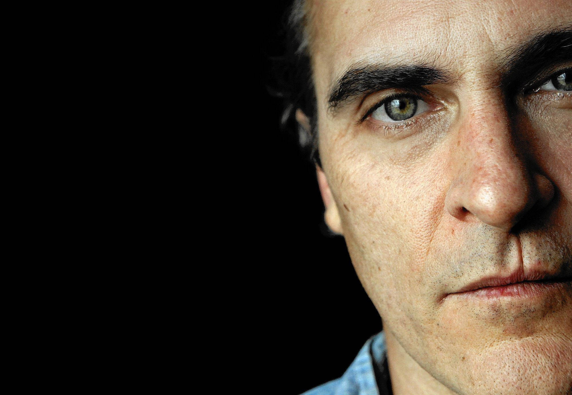 Joaquin Phoenix, intense green eyes, stark black background, Full HD Desktop Wallpaper