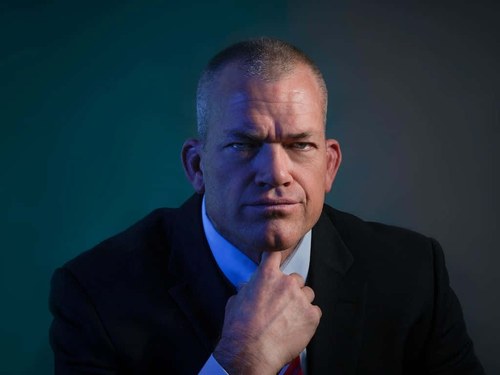 Jocko Willink, dark suit, teal and gray background, SD Desktop Wallpaper