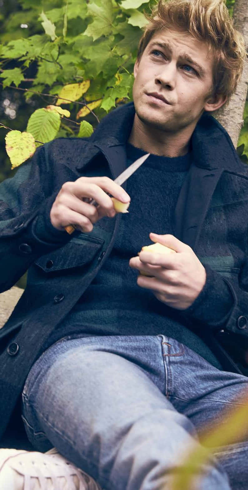 Joe Alwyn, tousled blonde hair, peeling an apple, HD Phone Wallpaper