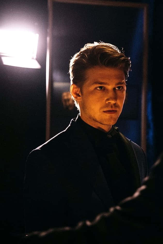 Joe Alwyn, dark suit, dimly lit room, SD Phone Wallpaper