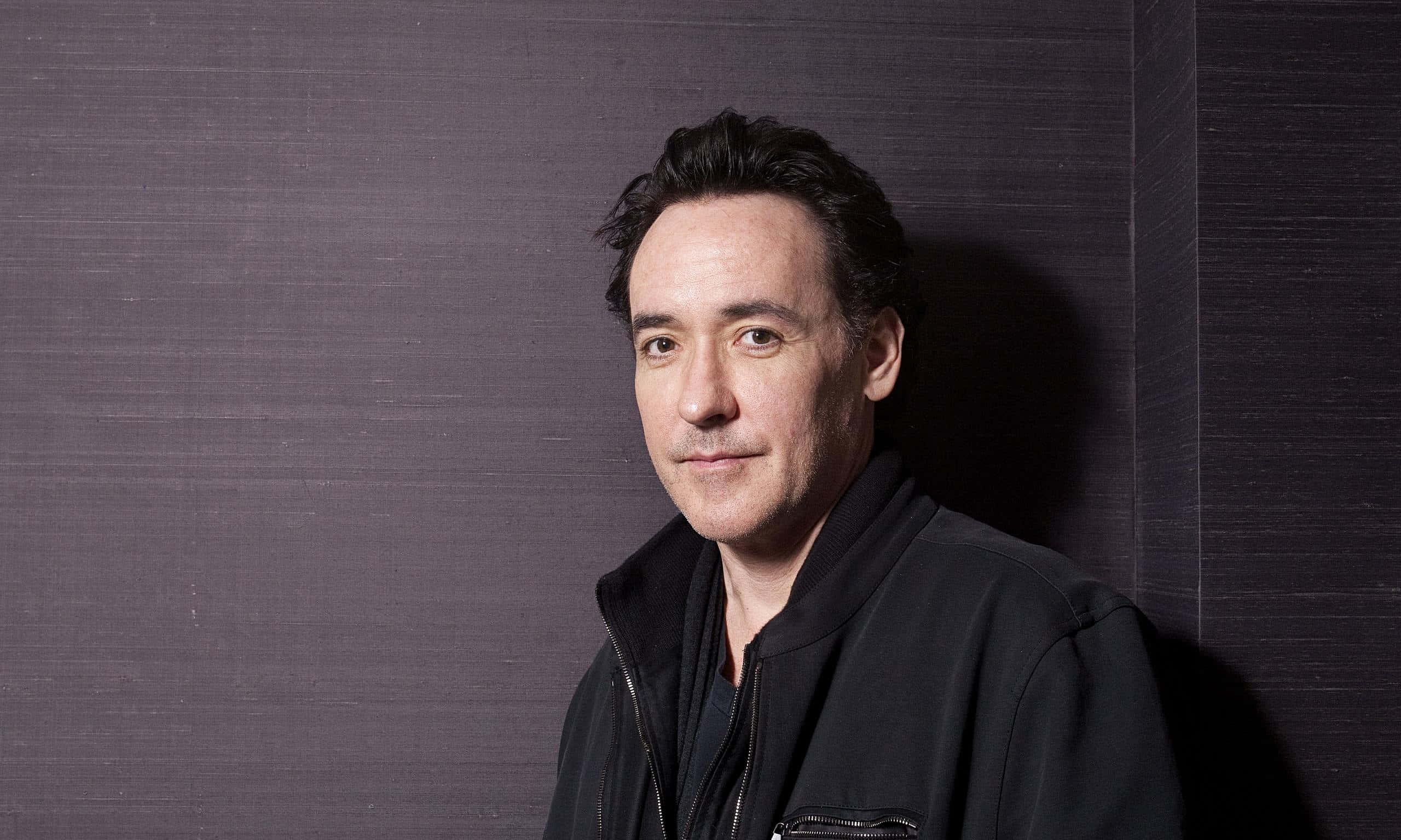 John Cusack, black jacket, dark textured wall, 2K Desktop Wallpaper