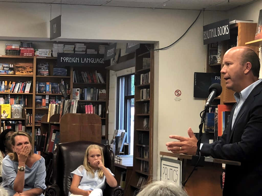 John Delaney, bookstore podium, suit, SD Desktop Wallpaper