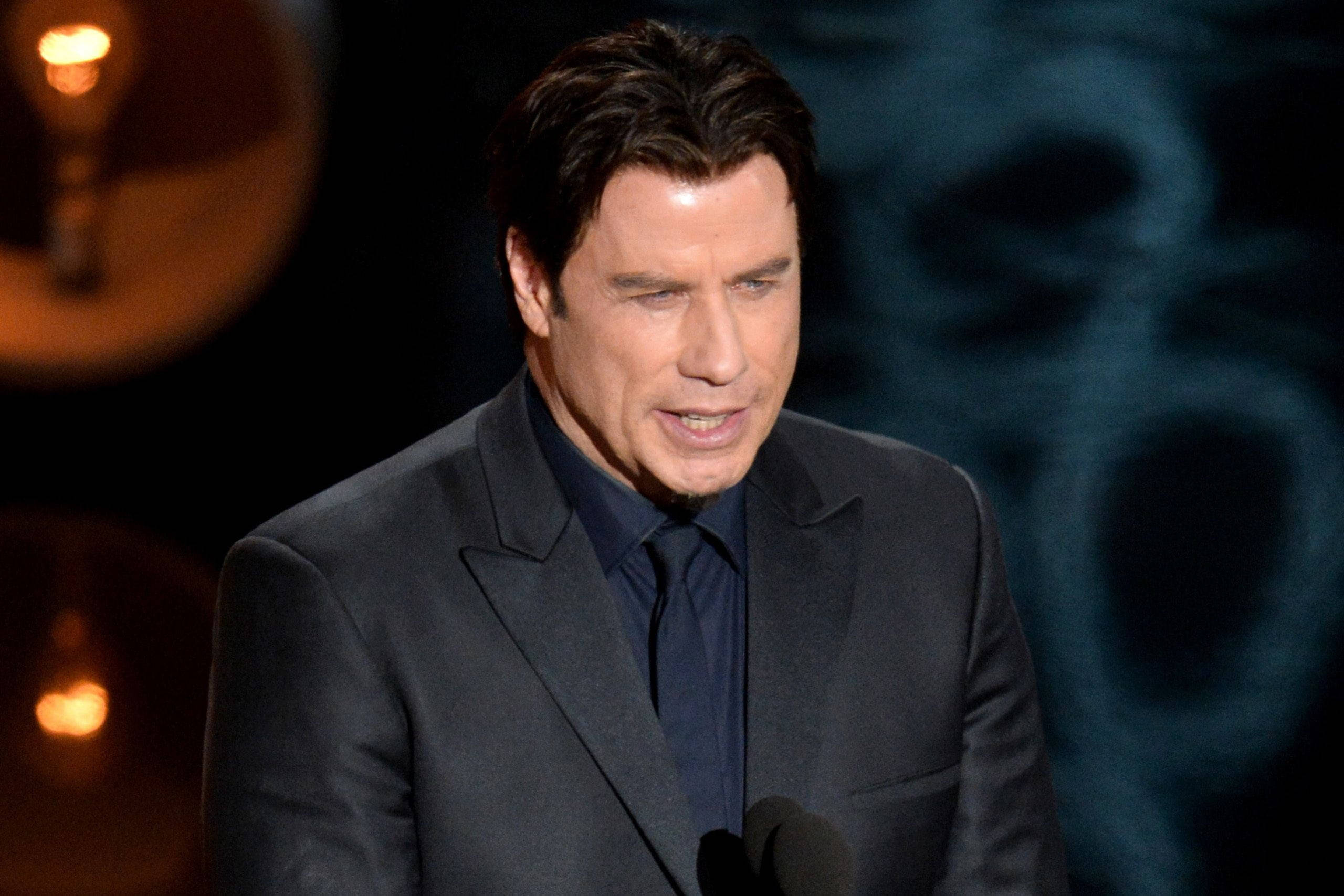 John Travolta, awards ceremony, warm stage lights, 2K Desktop Wallpaper