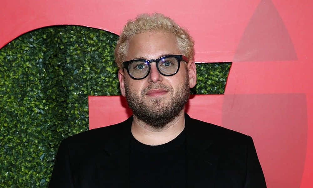 Jonah Hill, pink wall, green hedge cutout, SD Desktop Wallpaper