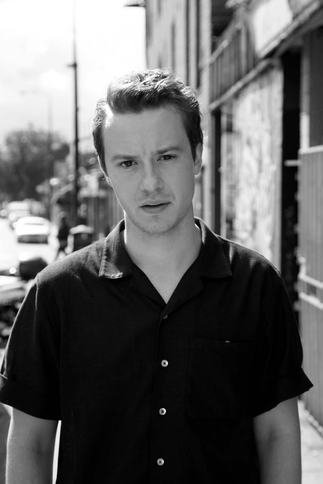 Joseph Quinn, black shirt, sunlit urban street, HD Phone Wallpaper