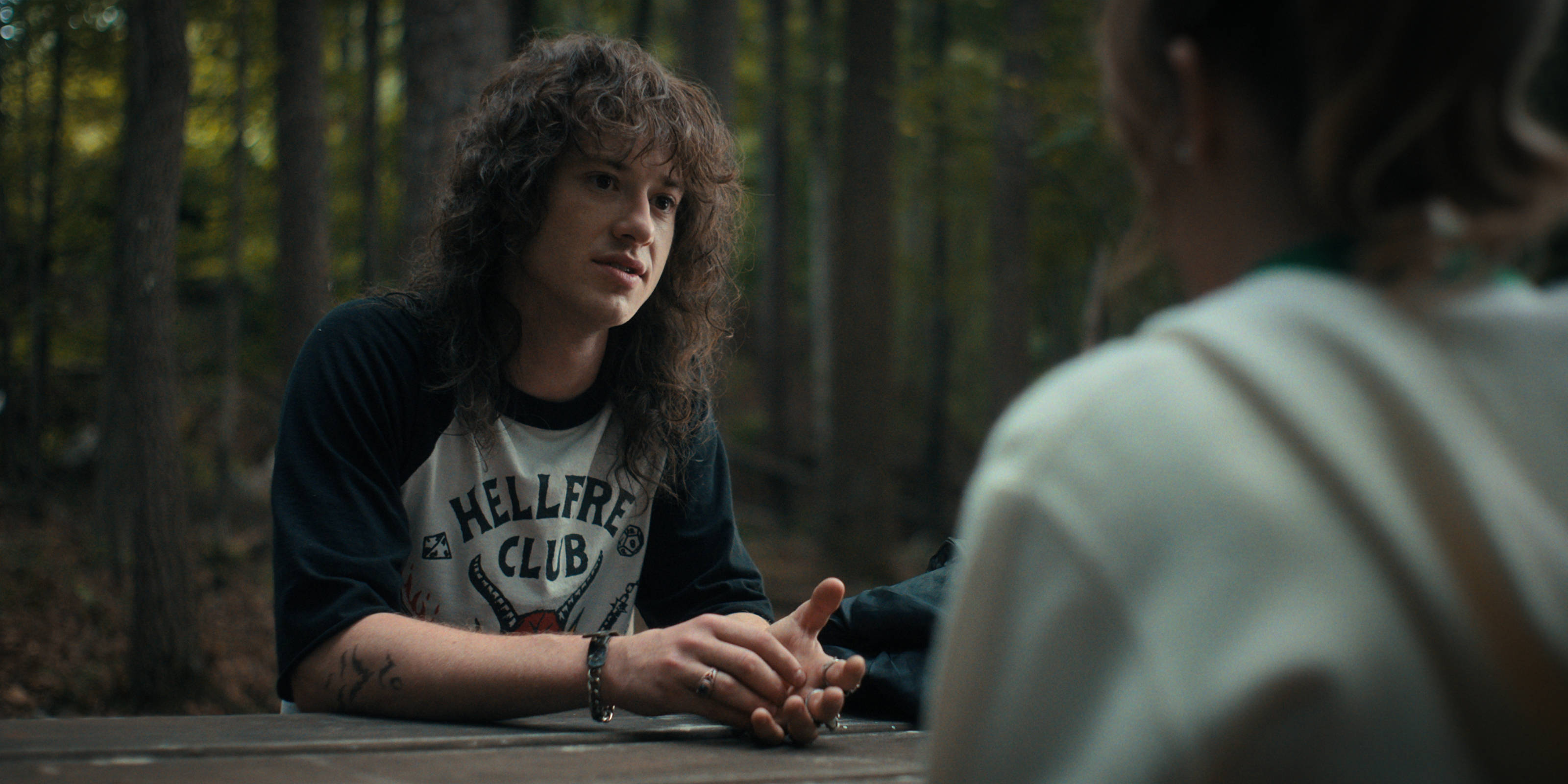 Joseph Quinn, picnic table, forest, 2K Desktop Wallpaper