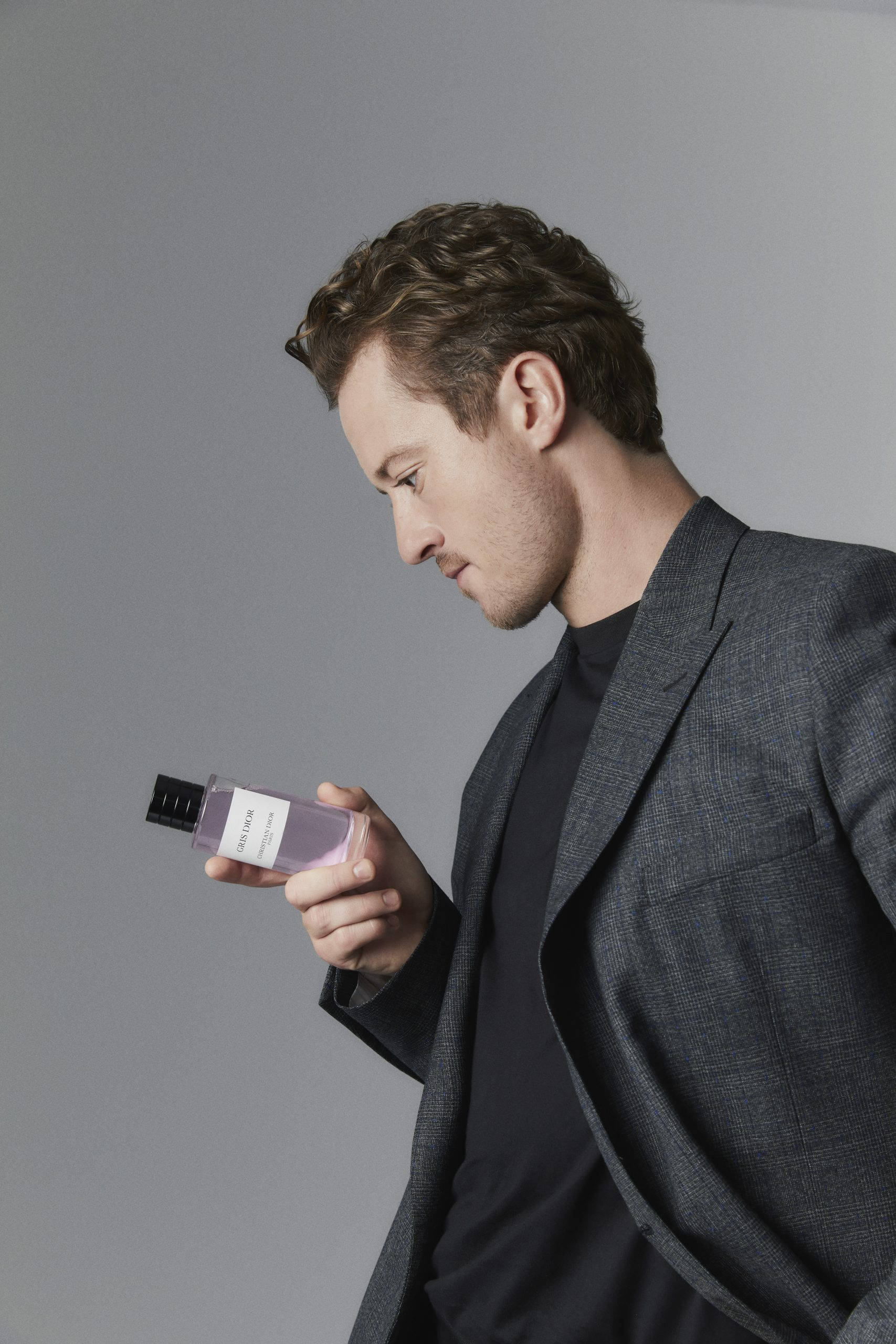 Joseph Quinn, grey suit, purple perfume bottle, 2K Phone Wallpaper