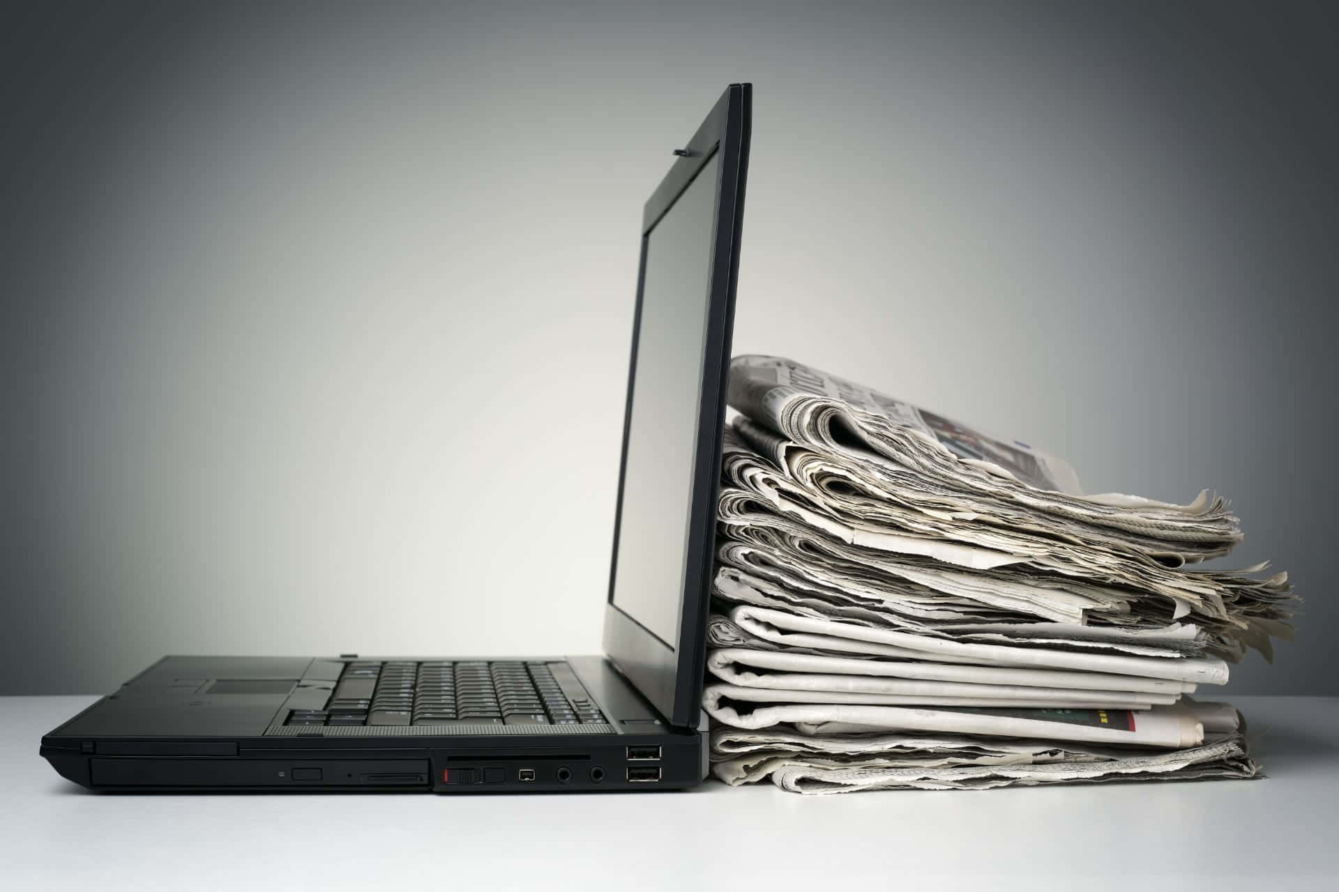 black laptop, folded newspapers, white surface, Full HD Desktop Wallpaper