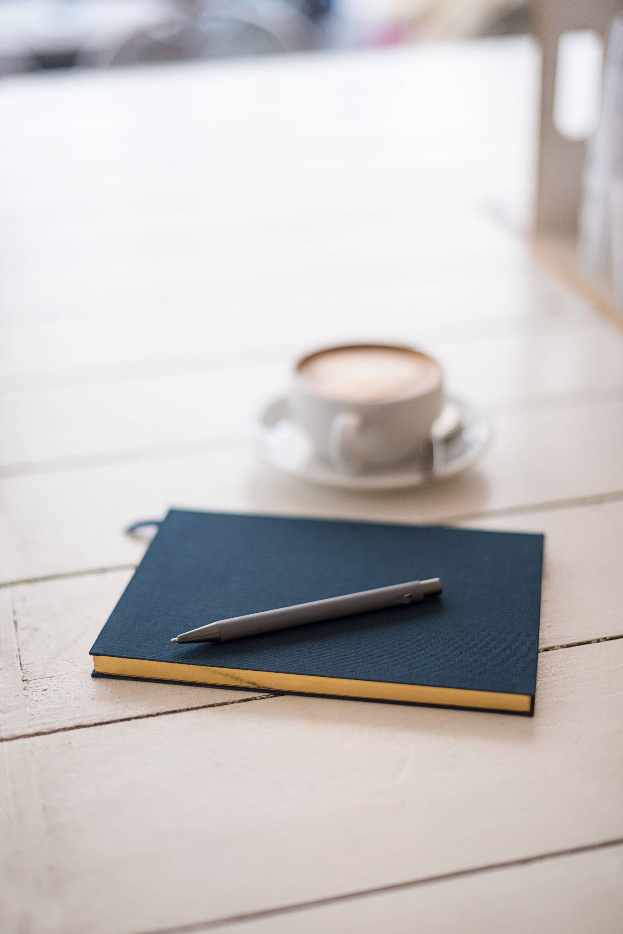 navy notebook, silver pen, white wooden table, 2K Phone Wallpaper