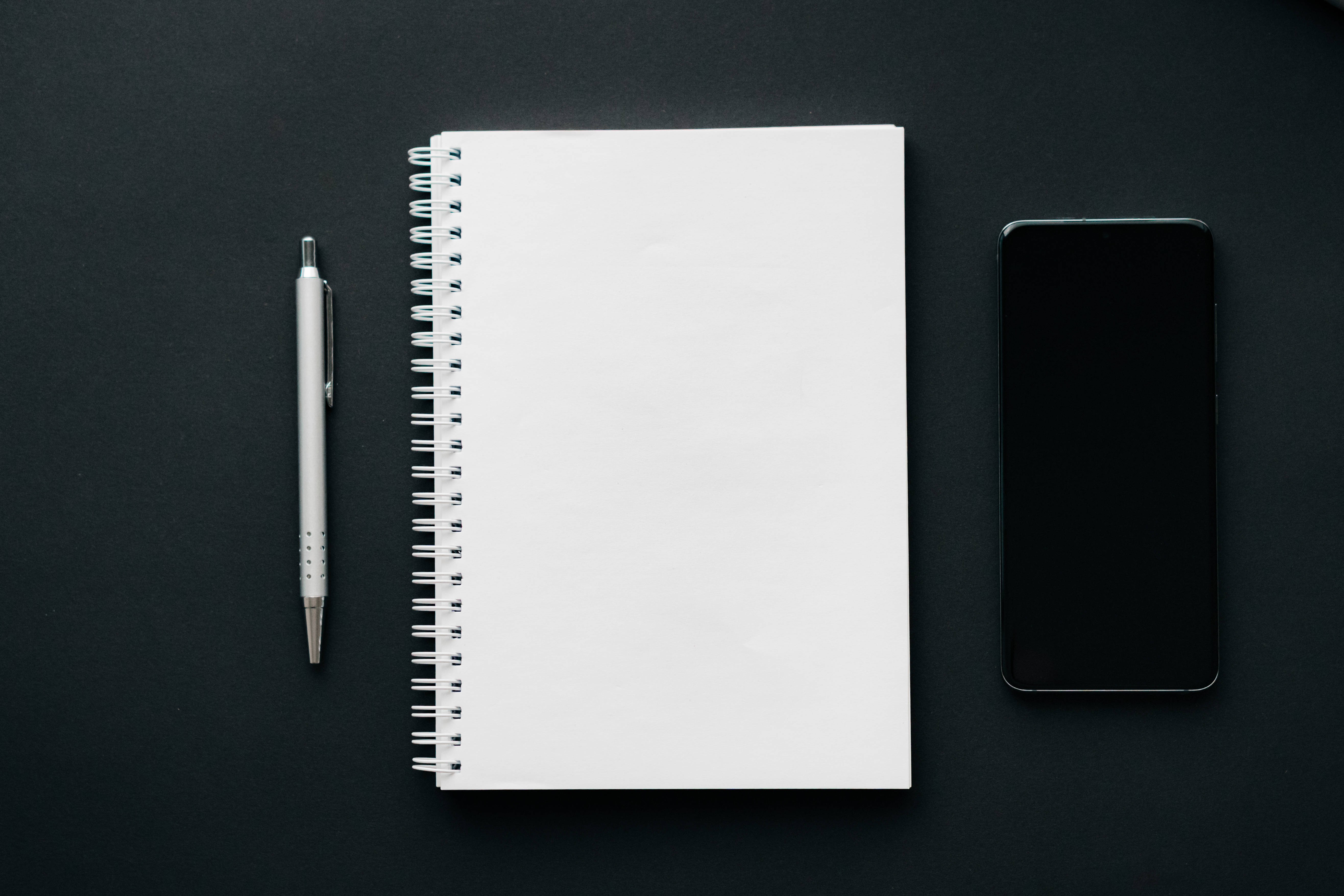 white spiral notebook, silver pen, black smartphone, 5K Desktop Wallpaper
