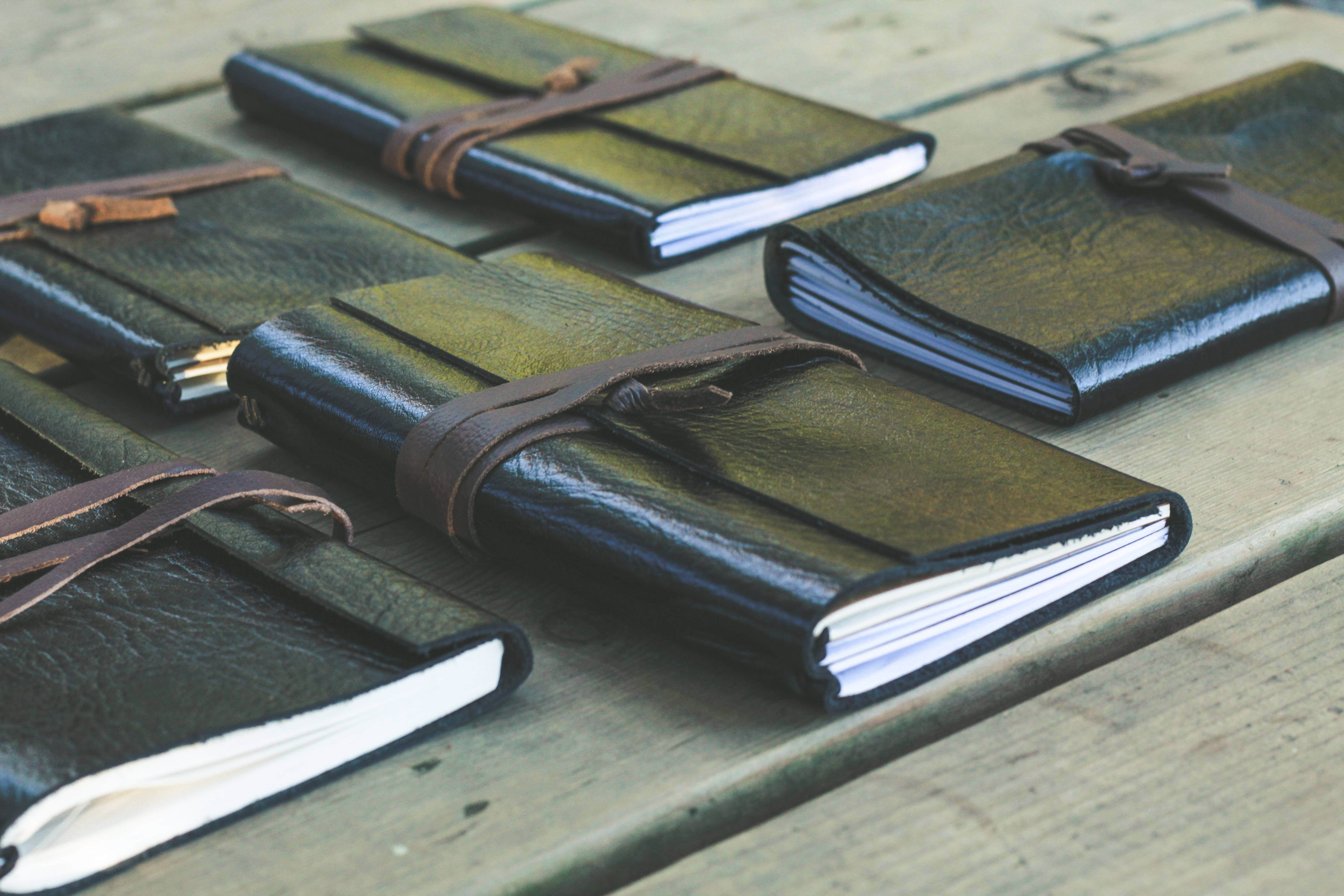 black leather cover, brown leather straps, weathered wooden surface, 5K Desktop Wallpaper