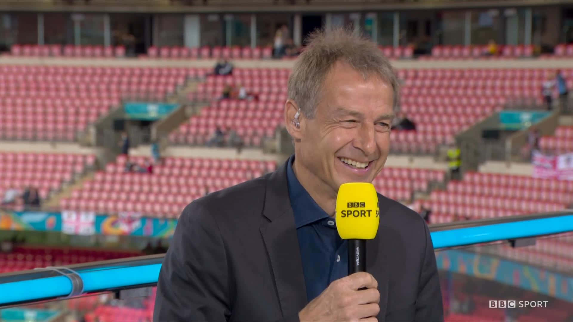 Jurgen Klinsmann, yellow BBC Sport microphone, empty stadium, Full HD Desktop Wallpaper