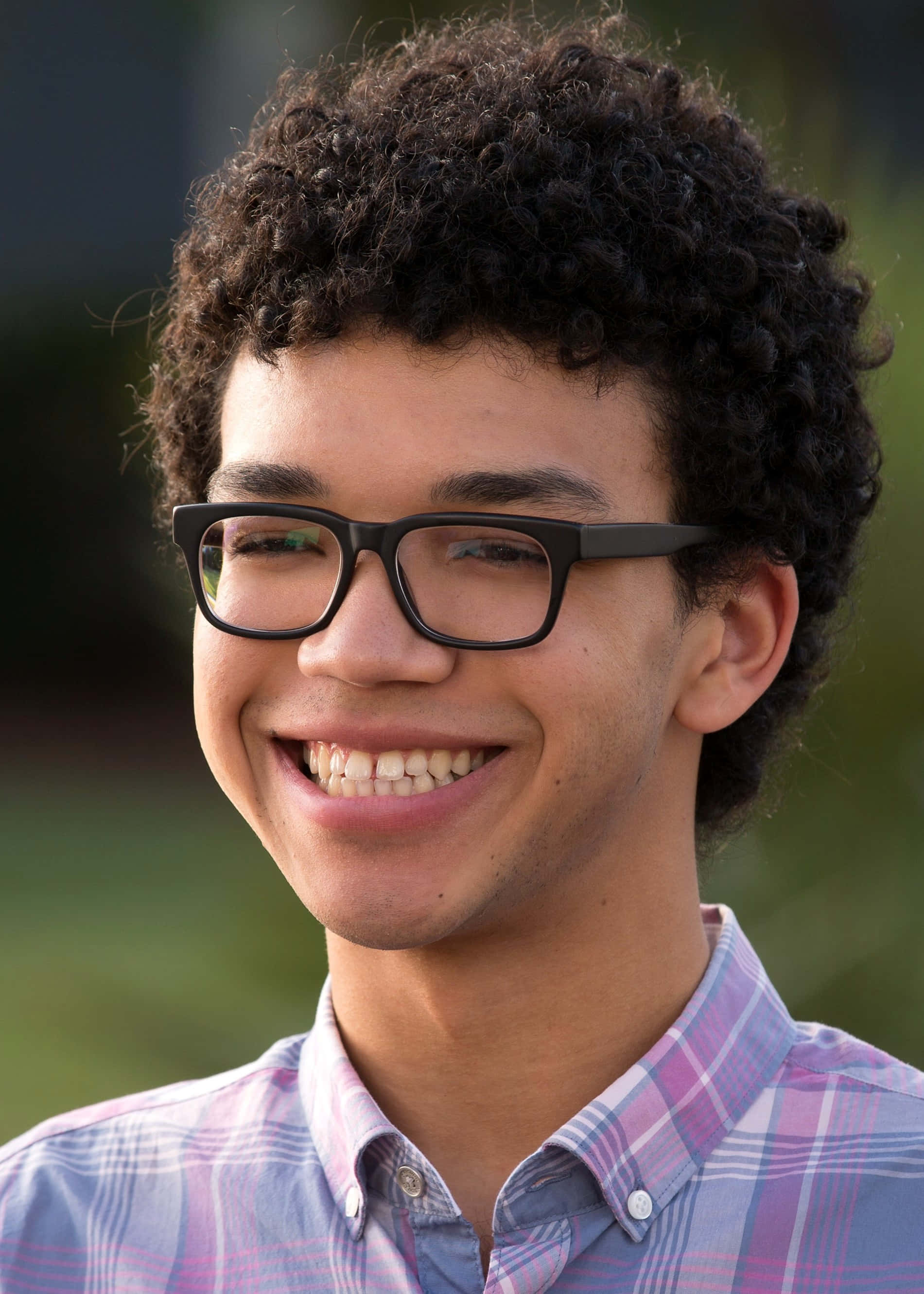 Justice Smith, curly dark hair, black glasses, 2K Phone Wallpaper