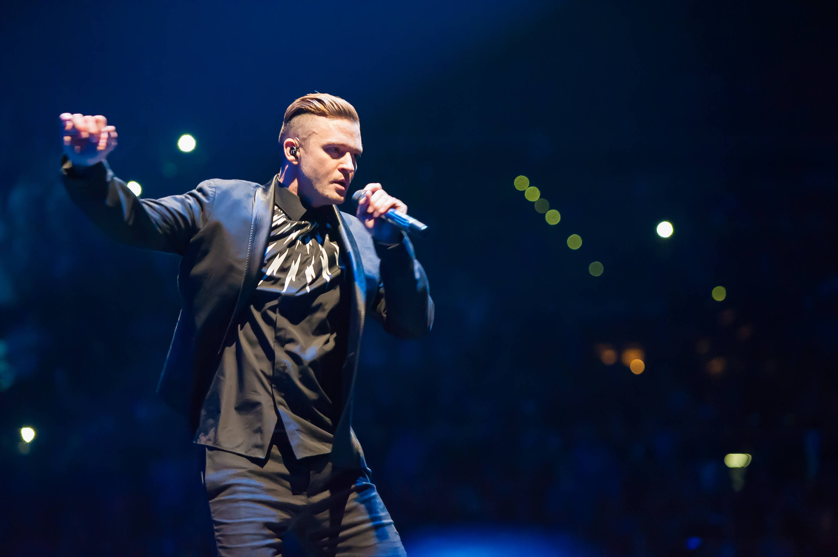 Justin Timberlake, black suit, dimly lit stage, 2K Desktop Wallpaper
