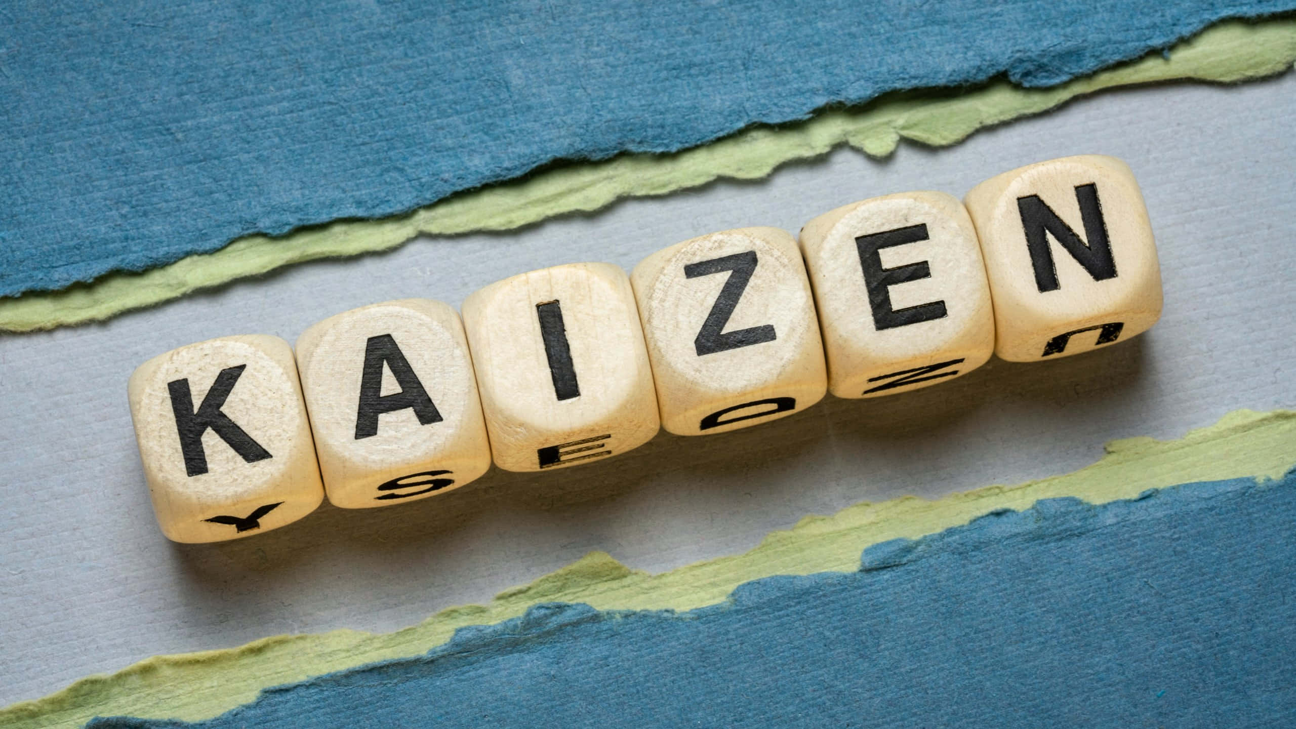 kaizen, wooden letter cubes, torn blue and green paper, 2K Desktop Wallpaper