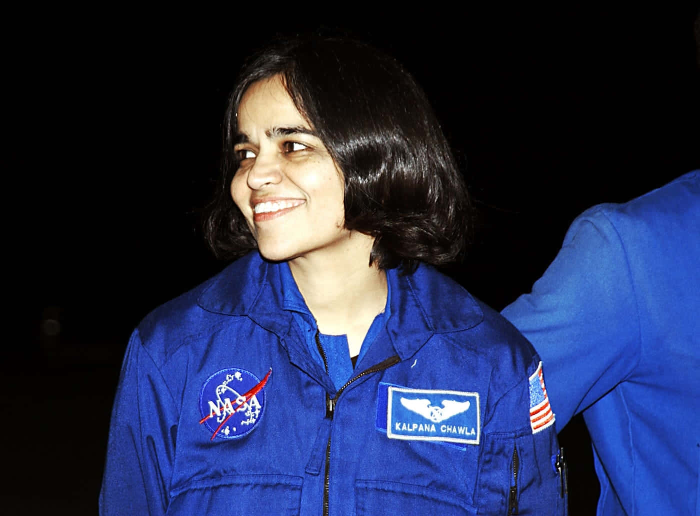 Kalpana Chawla, blue NASA flight suit, dark background, HD Desktop Wallpaper