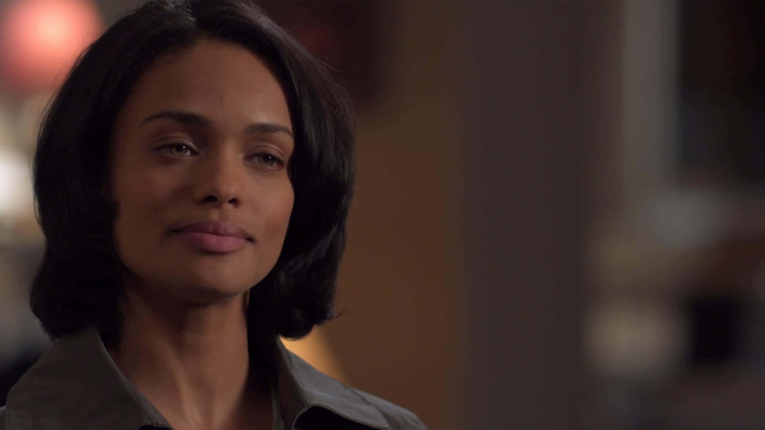 Kandyse McClure, short dark hair, warmly lit indoor setting, 2K Desktop Wallpaper
