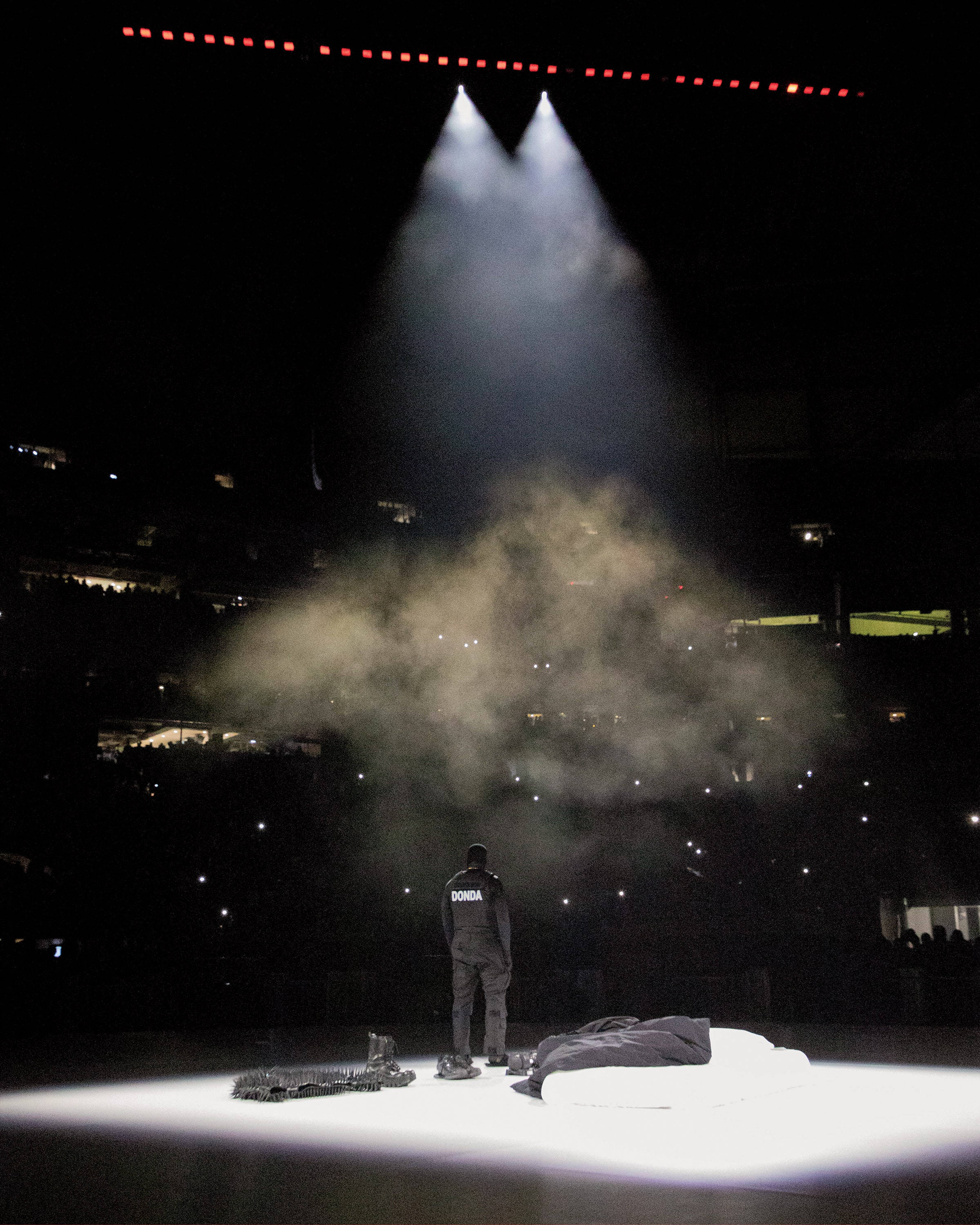 Kanye West Donda, dimly lit stage, dramatic spotlights, 2K Phone Wallpaper