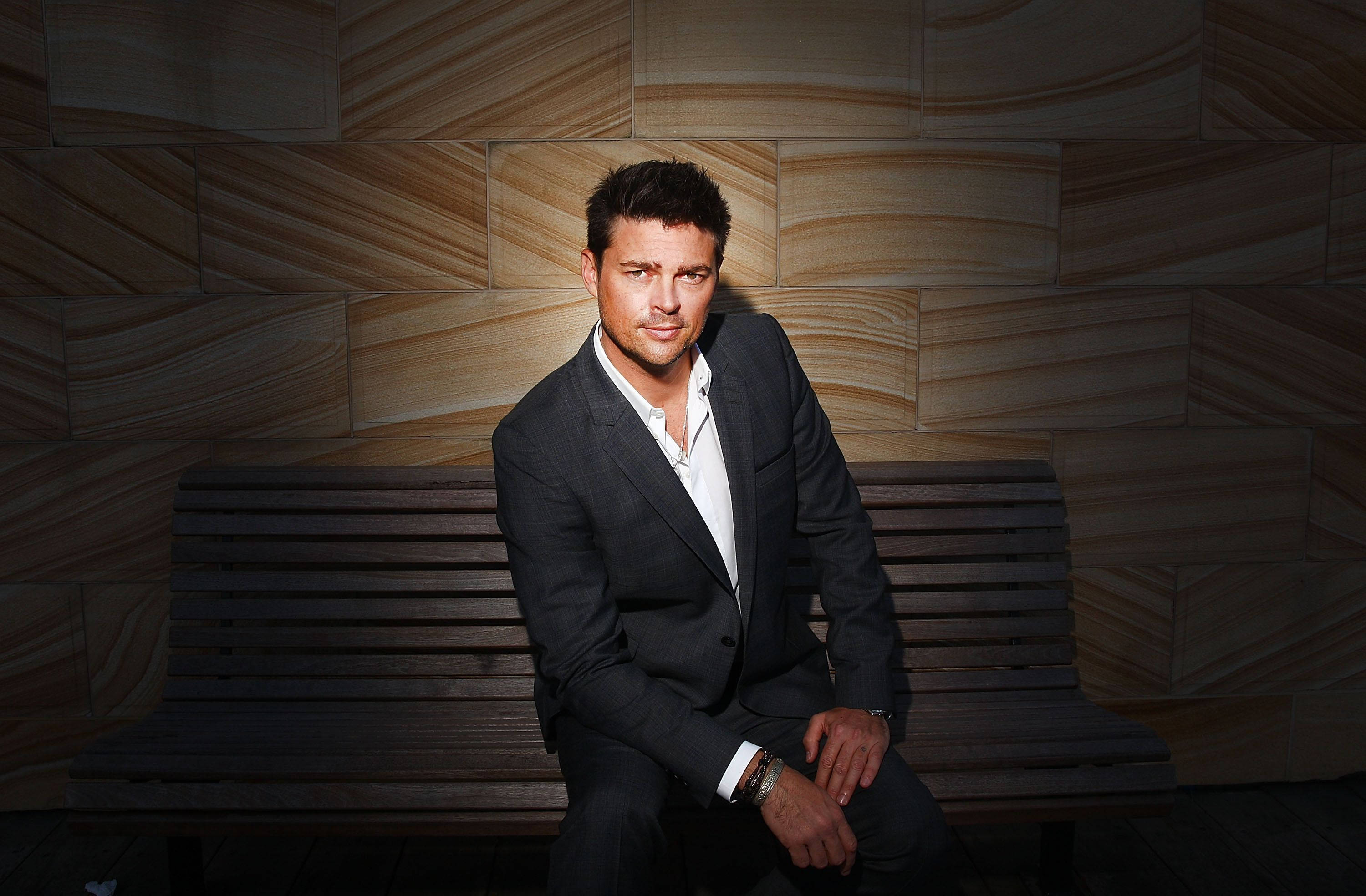 Karl Urban, dark suit, wooden bench, 2K Desktop Wallpaper