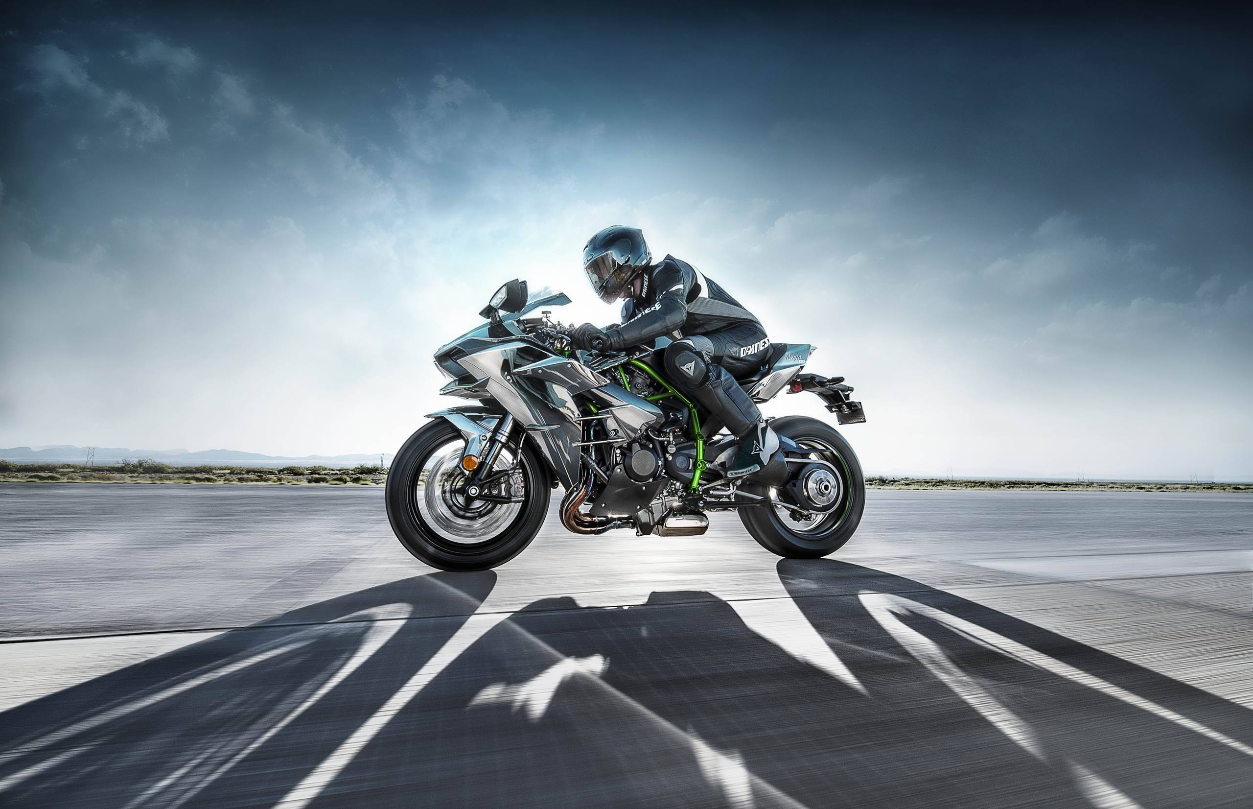 Kawasaki H2R, sleek silver and green sport motorcycle, dramatic cloudy sky, 2K Desktop Wallpaper