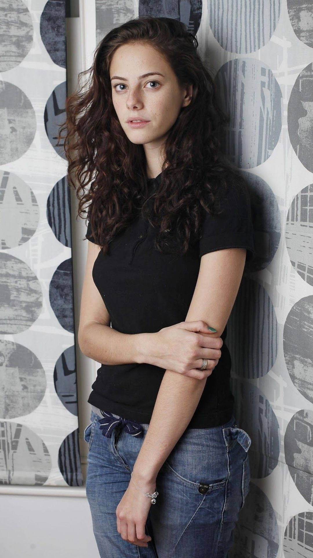 Kaya Scodelario, curly brown hair, wall, Full HD Phone Wallpaper