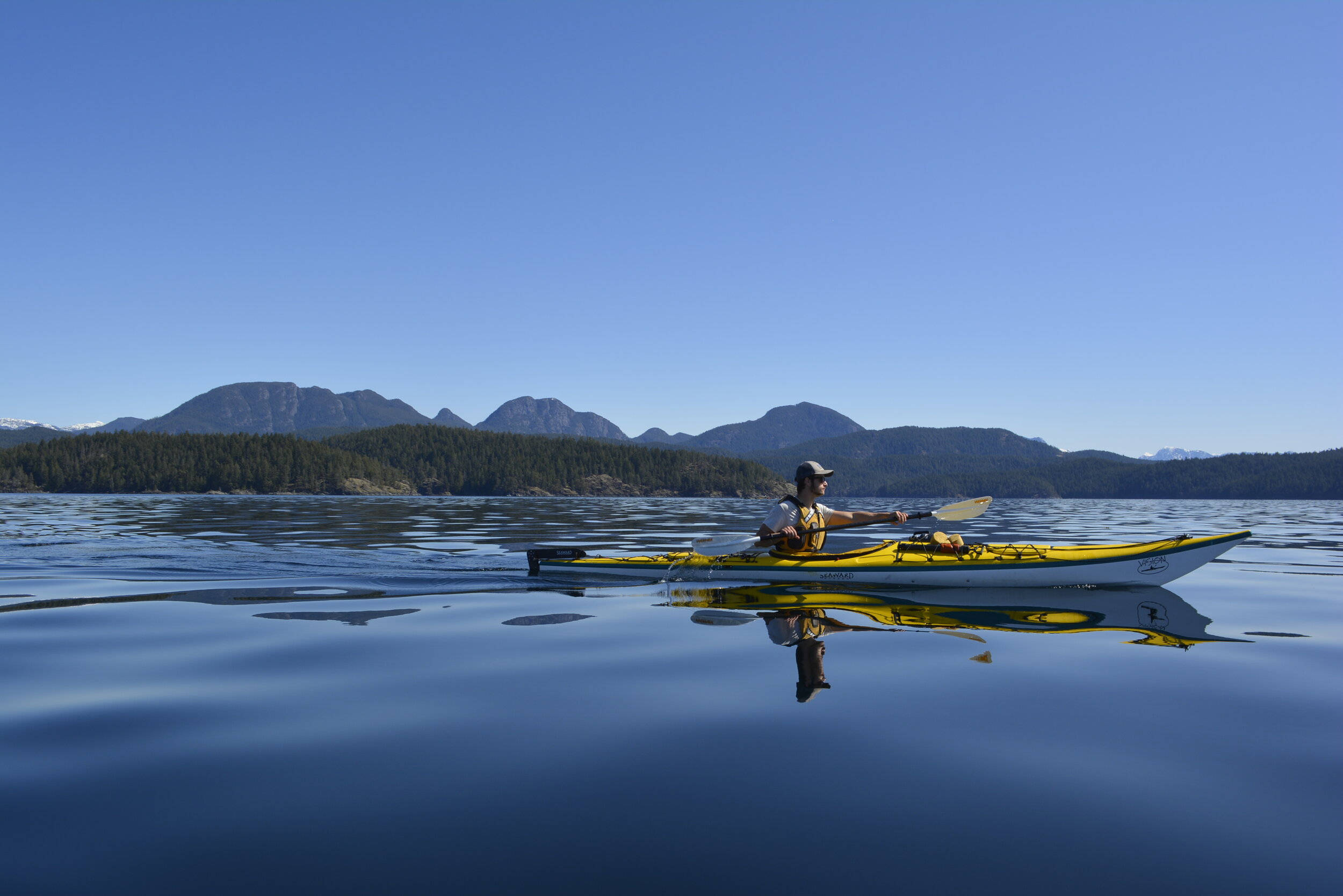bright yellow kayak, glassy blue lake, forested mountains, Full HD Desktop Wallpaper