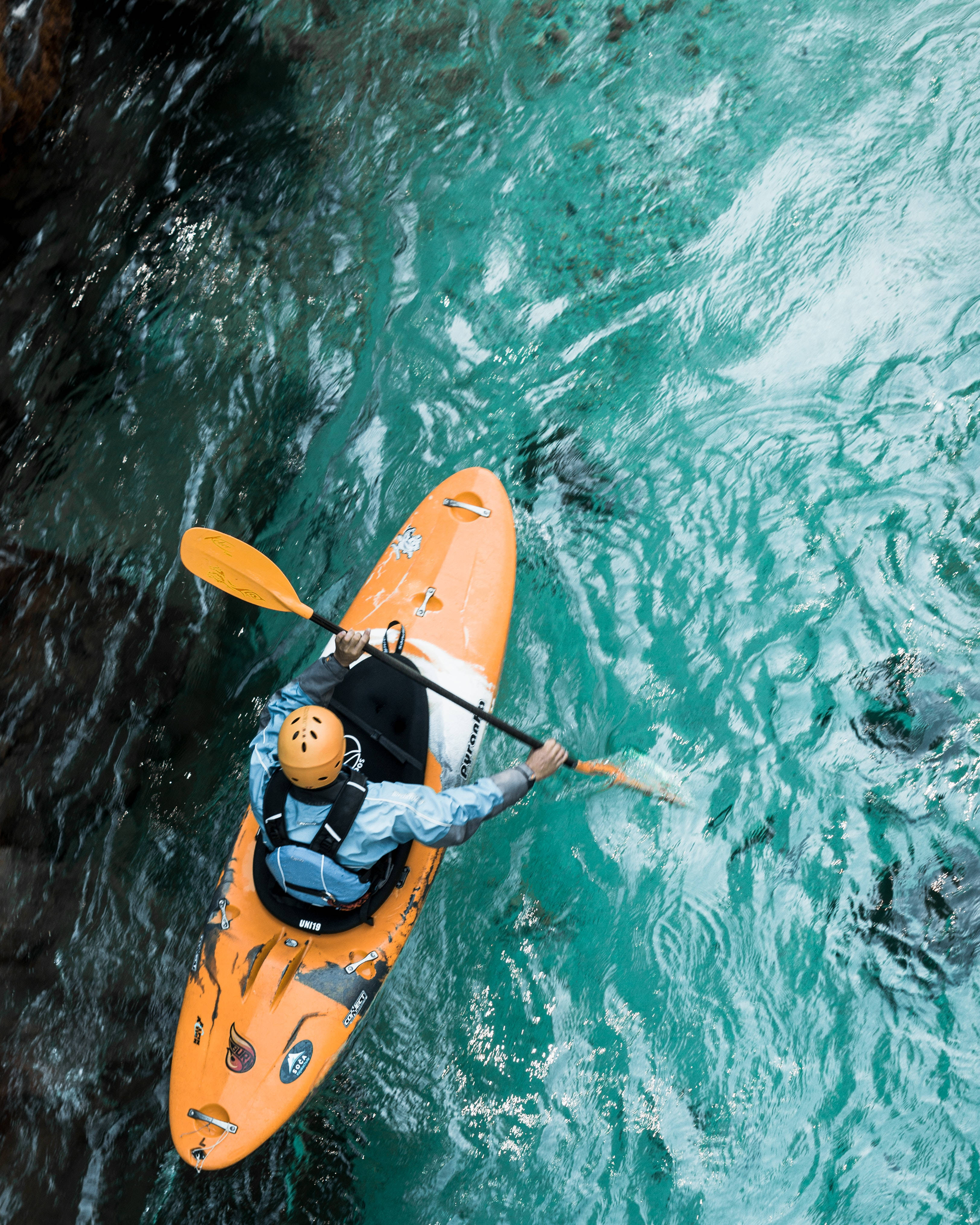 orange kayak, vibrant turquoise waters, dark rocky cliffs, 4K Phone Wallpaper