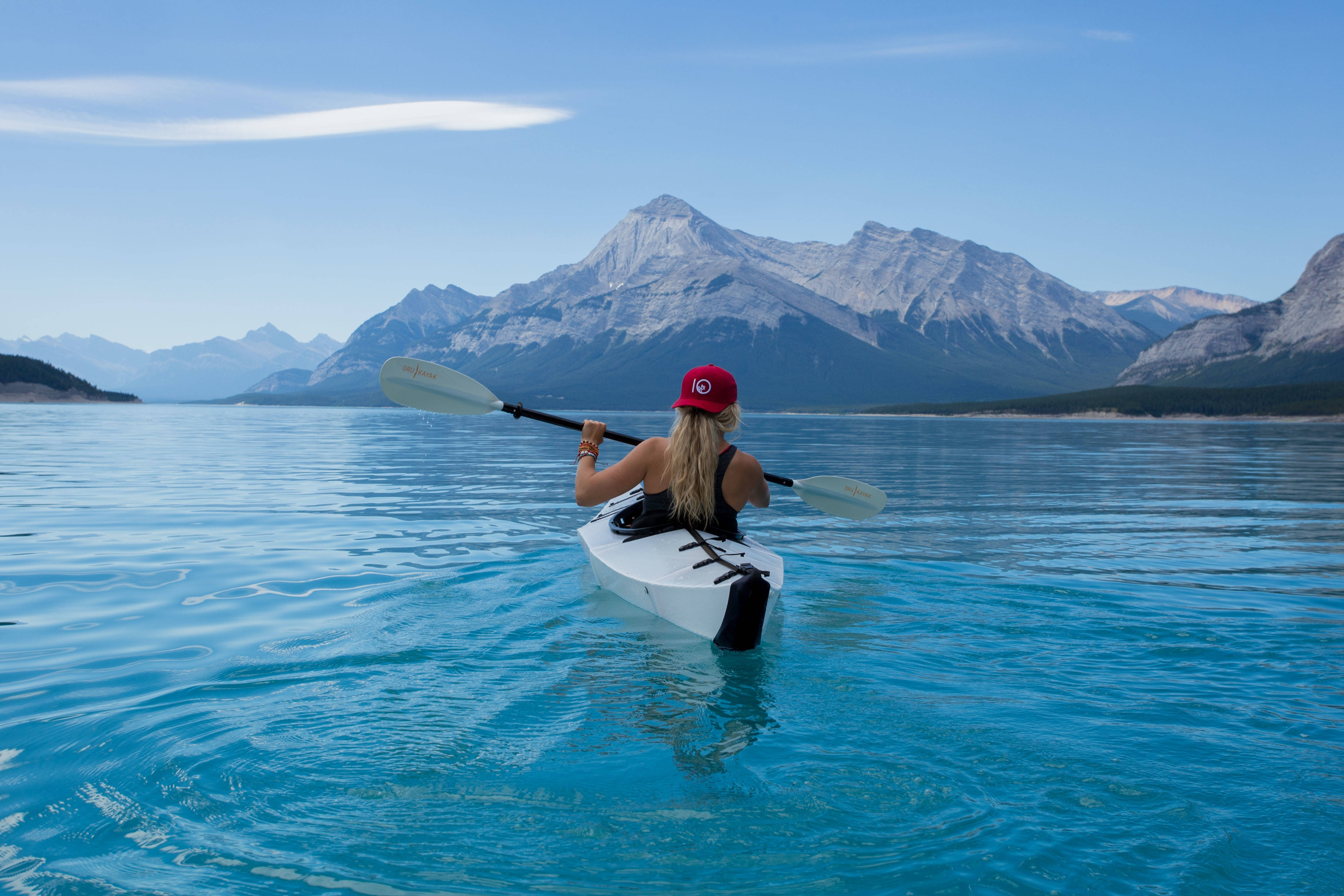 white kayak, calm turquoise waters, snow-capped mountains, 4K Desktop Wallpaper