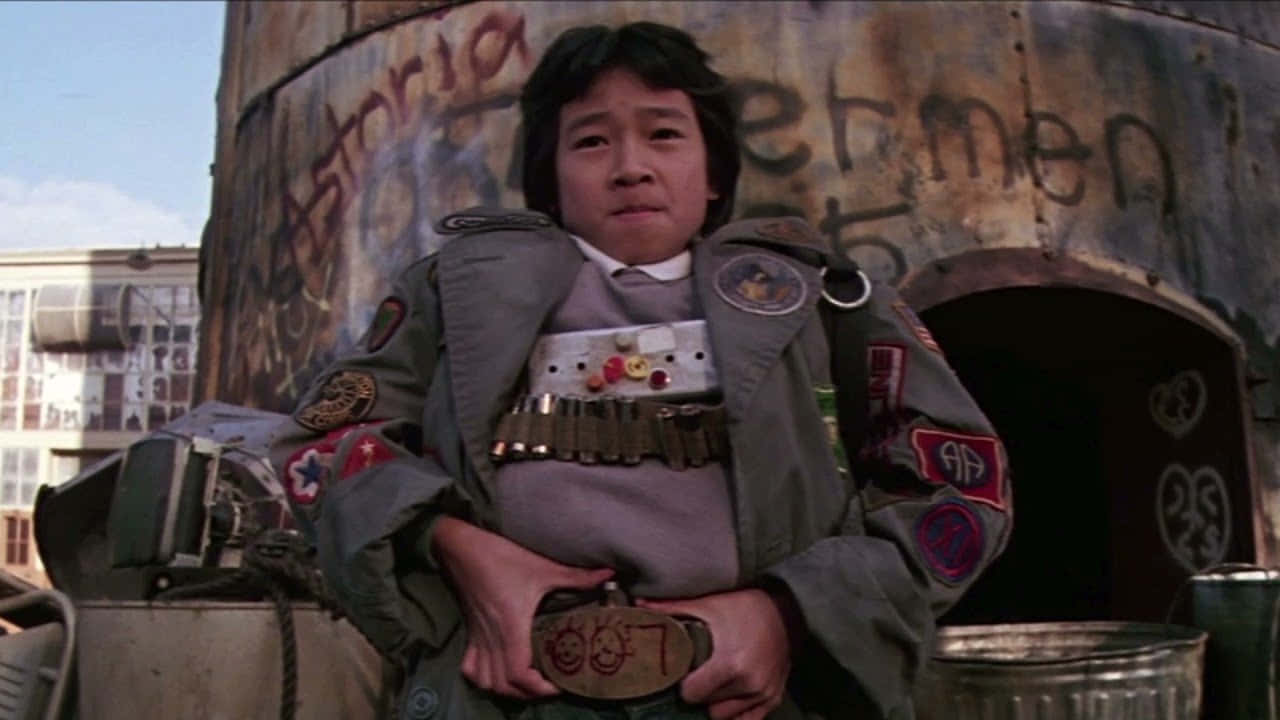 Ke Huy Quan, patched military jacket, graffiti-covered rusted tank, HD Desktop Wallpaper
