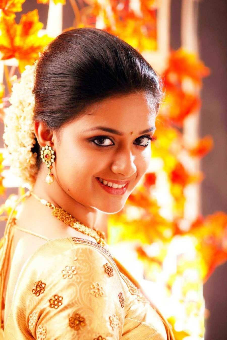 Keerthi Suresh, golden traditional attire, vibrant orange floral backdrop, HD Phone Wallpaper