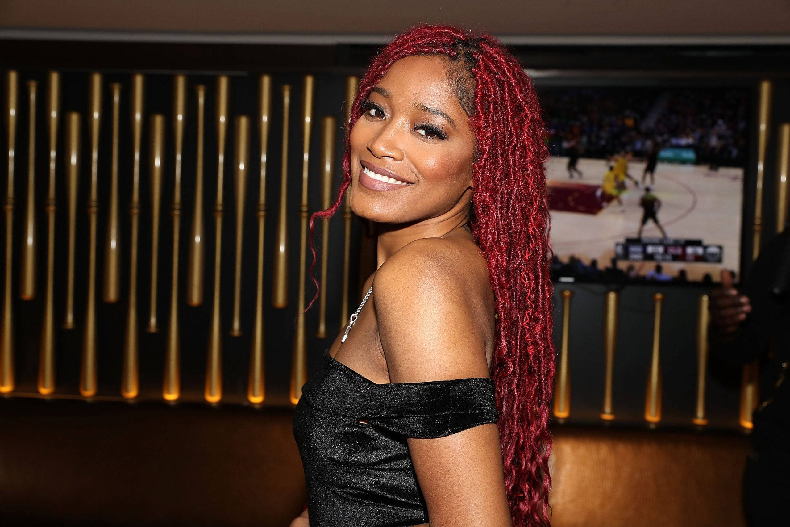Keke Palmer, vibrant red braids, dimly lit lounge, 2K Desktop Wallpaper