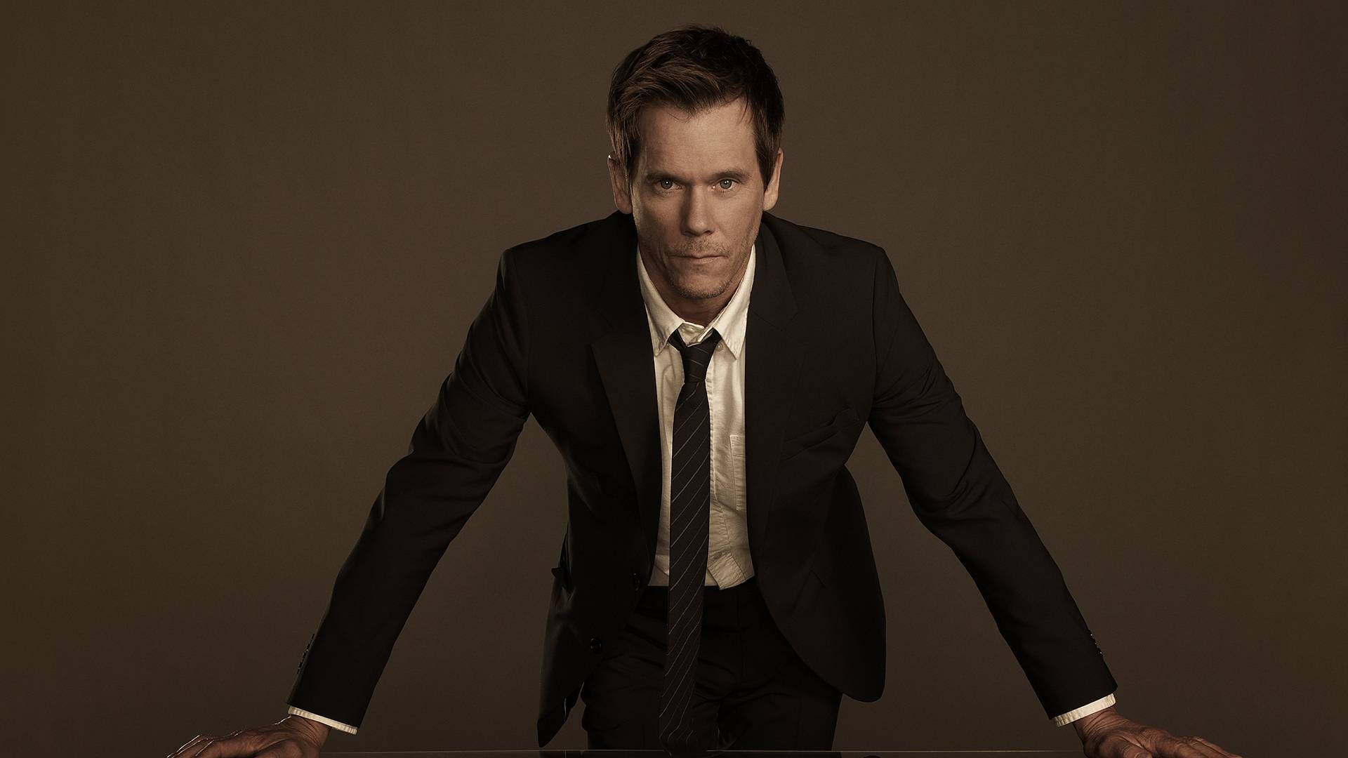 Kevin Bacon, black suit, muted brown studio backdrop, Full HD Desktop Wallpaper