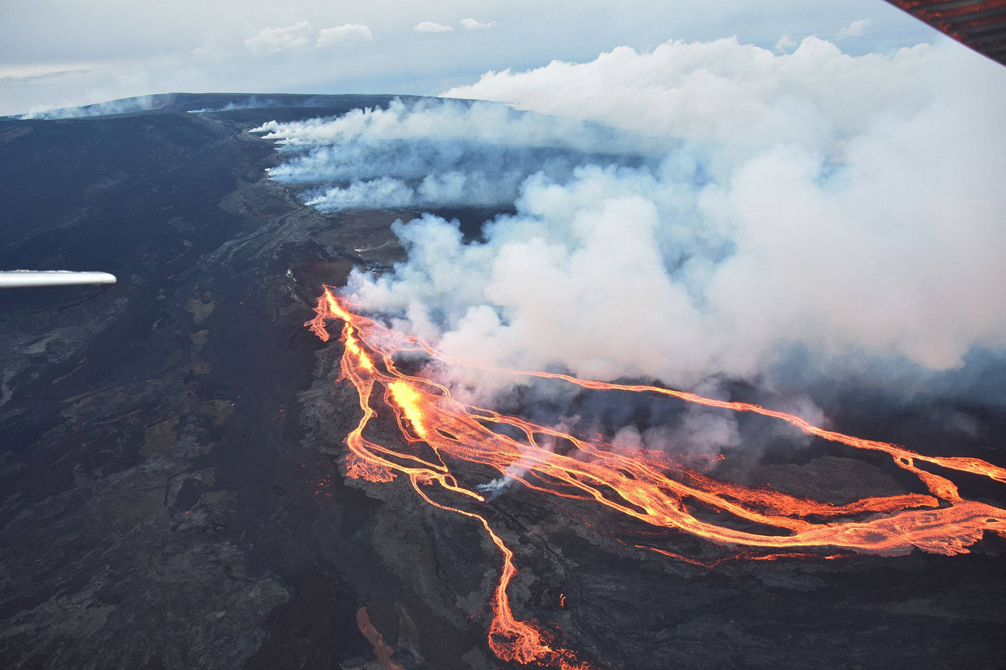 Kilauea Volcano, glowing orange lava flows, dark volcanic terrain, Full HD Desktop Wallpaper