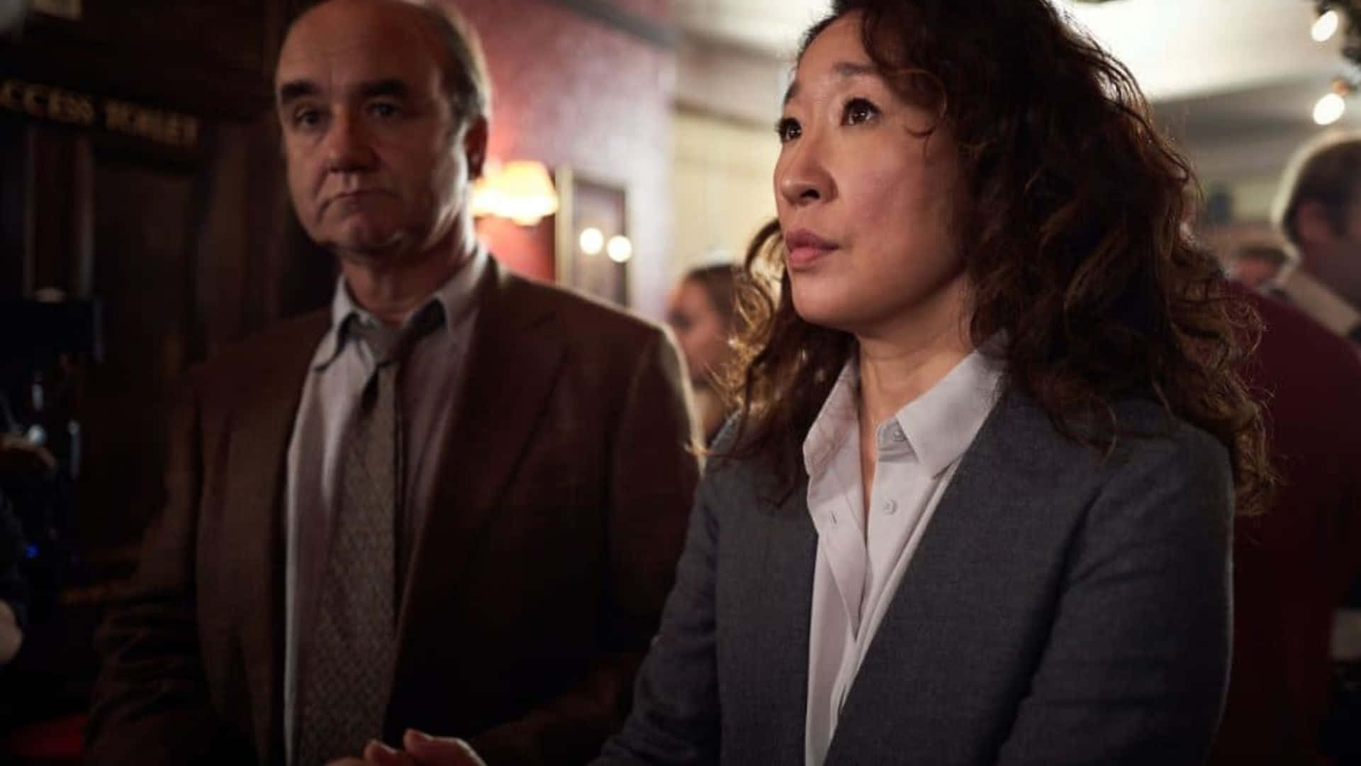 Killing Eve, formally dressed individuals, warmly lit indoor setting, Full HD Desktop Wallpaper