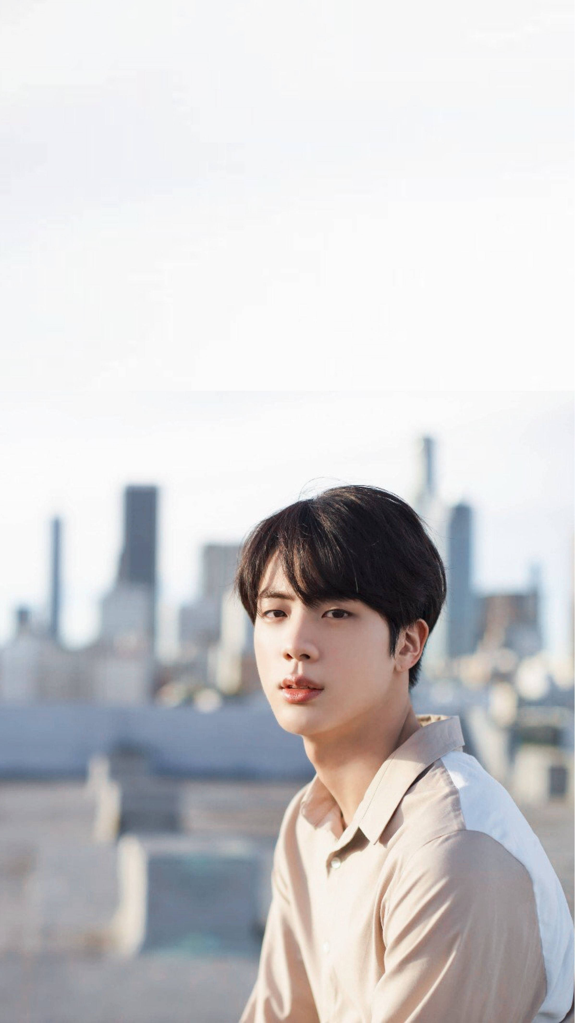 Kim Seok Jin, beige shirt, hazy city skyline, 4K Phone Wallpaper