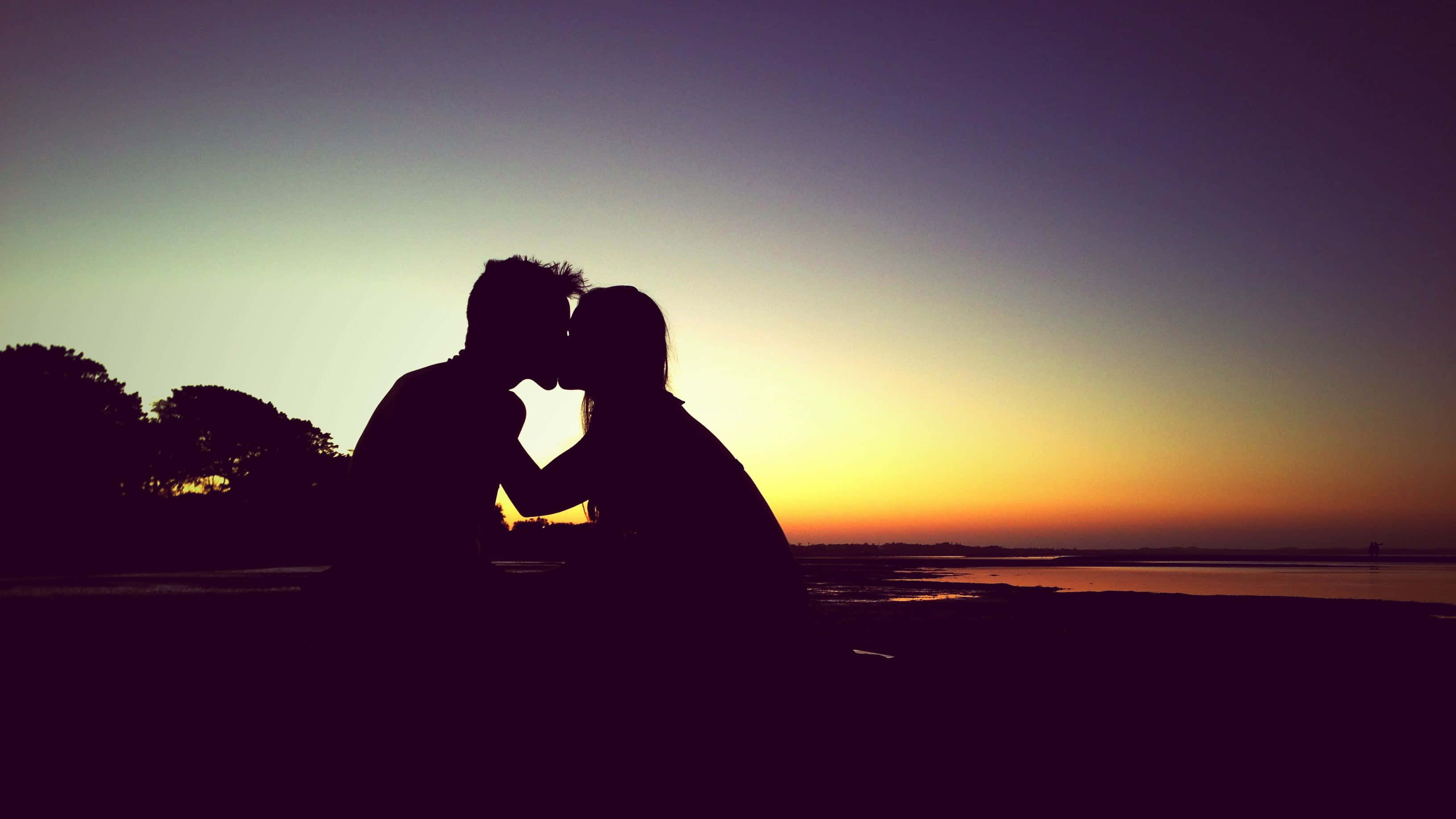 Horizontal Couple Kissing Their Lips, sunset, vibrant orange horizon, 2K Desktop Wallpaper
