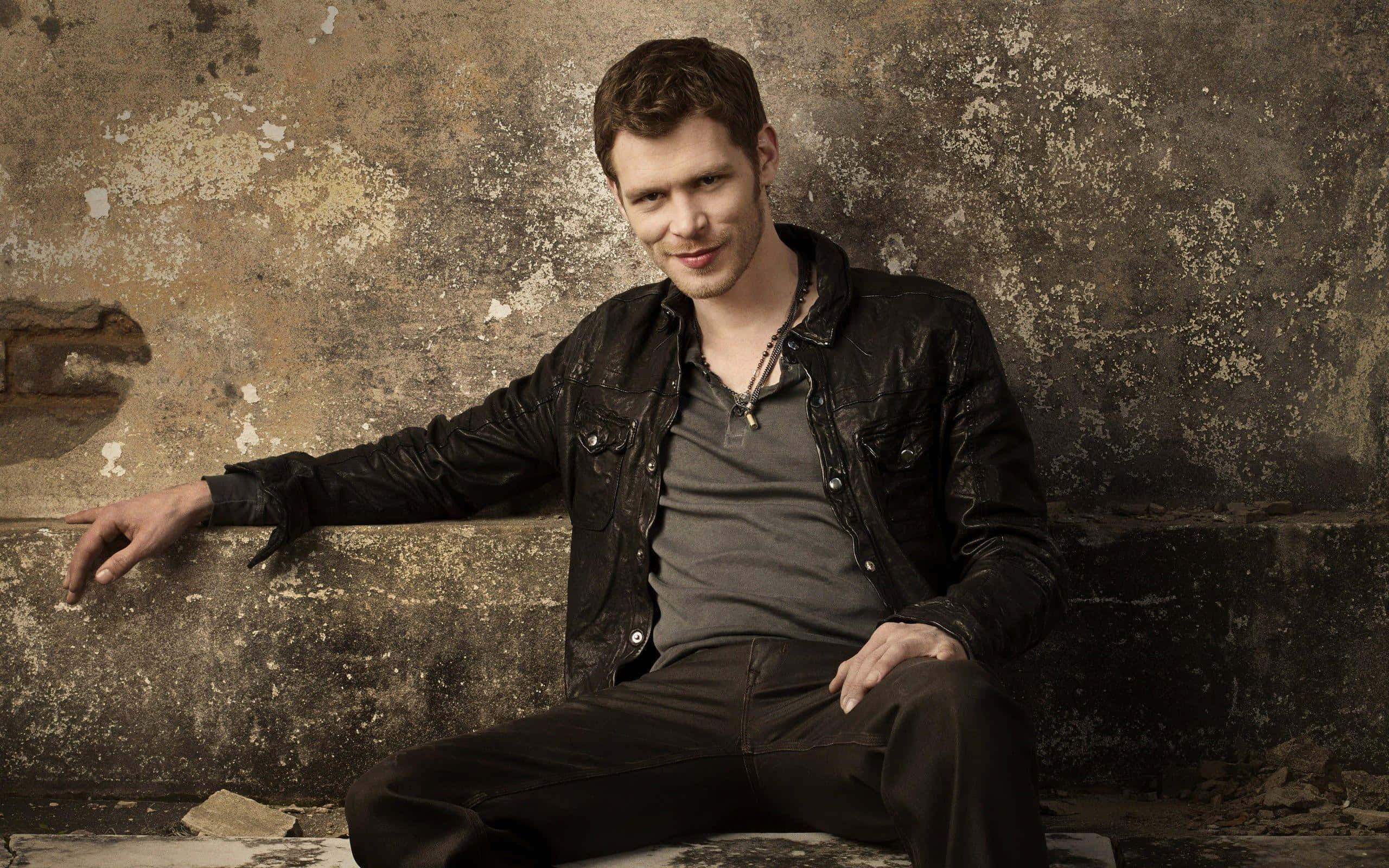 Klaus Mikaelson, black leather jacket, weathered concrete wall, 2K Desktop Wallpaper
