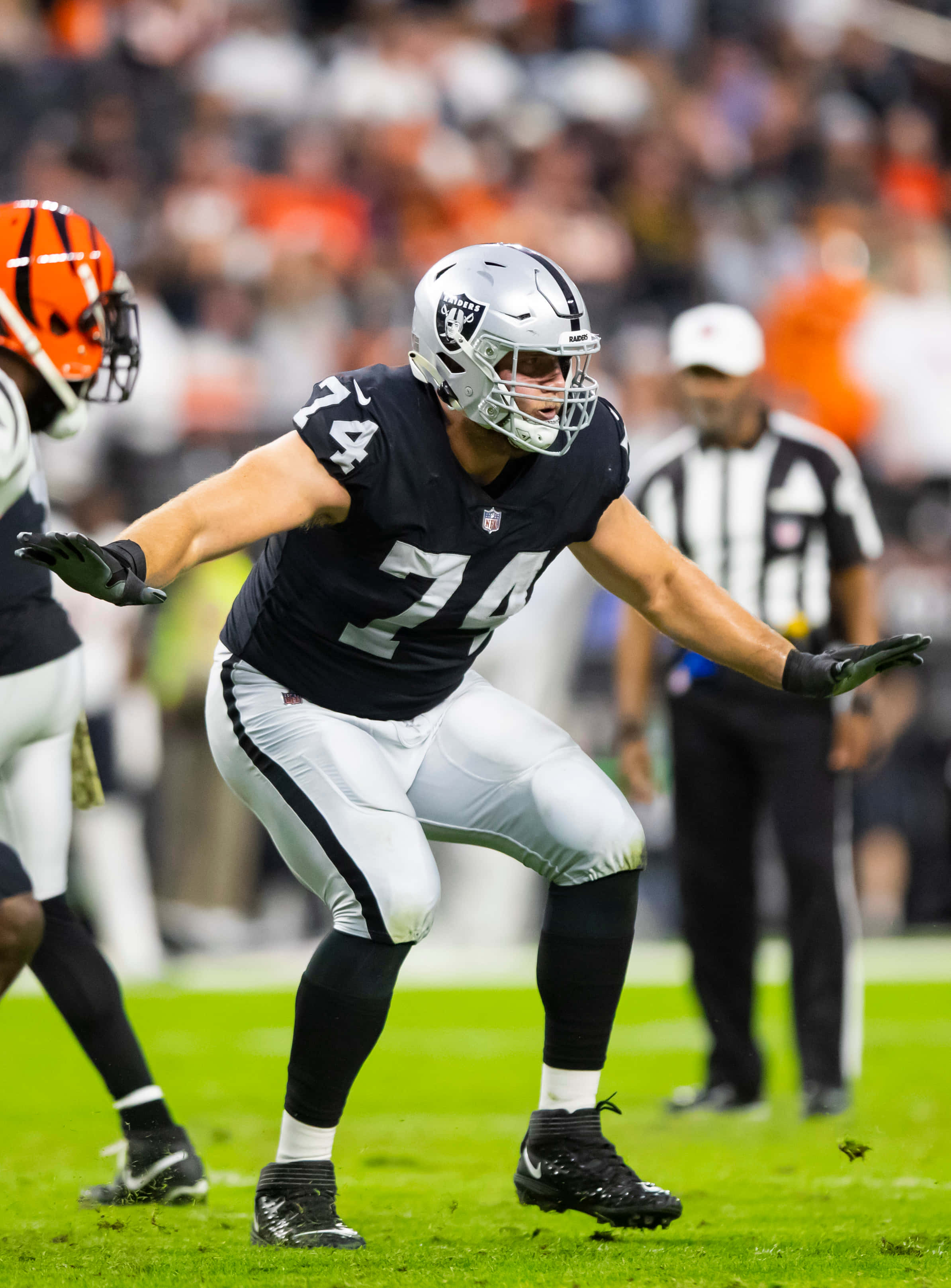 Kolton Miller, black and silver uniform, vibrant green field, 2K Phone Wallpaper