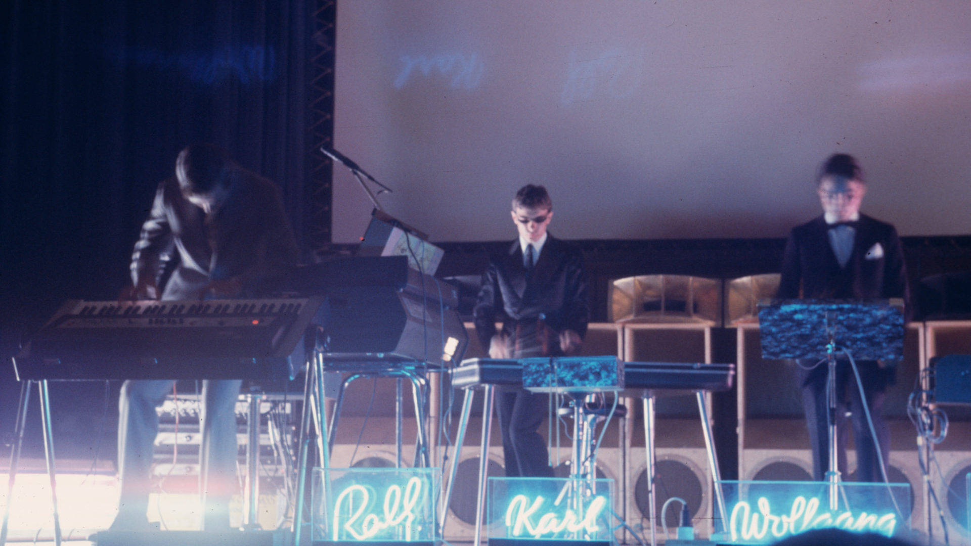 Kraftwerk, vintage synthesizers, dimly lit stage, Full HD Desktop Wallpaper