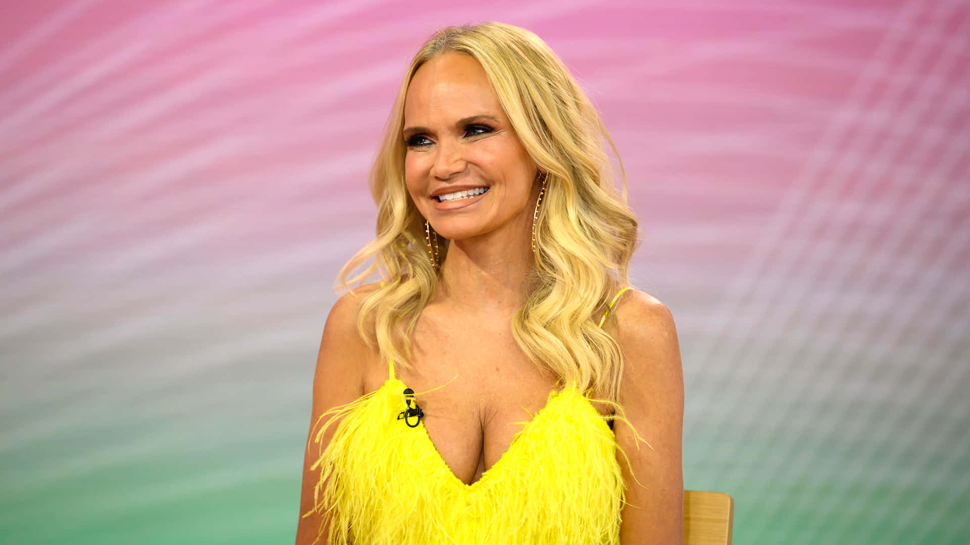 Kristin Chenoweth, bright yellow feathered top, soft pink and green gradient background, Full HD Desktop Wallpaper