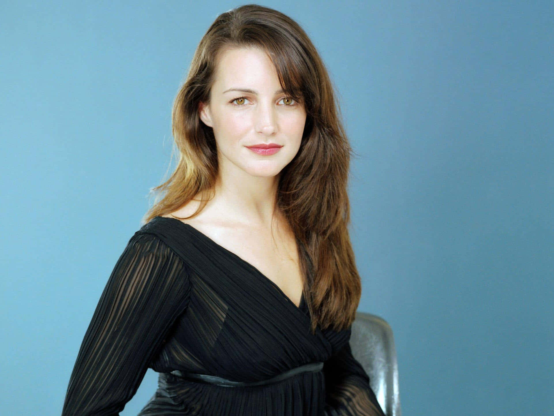 Kristin Davis, black pleated dress, solid blue studio background, Full HD Desktop Wallpaper