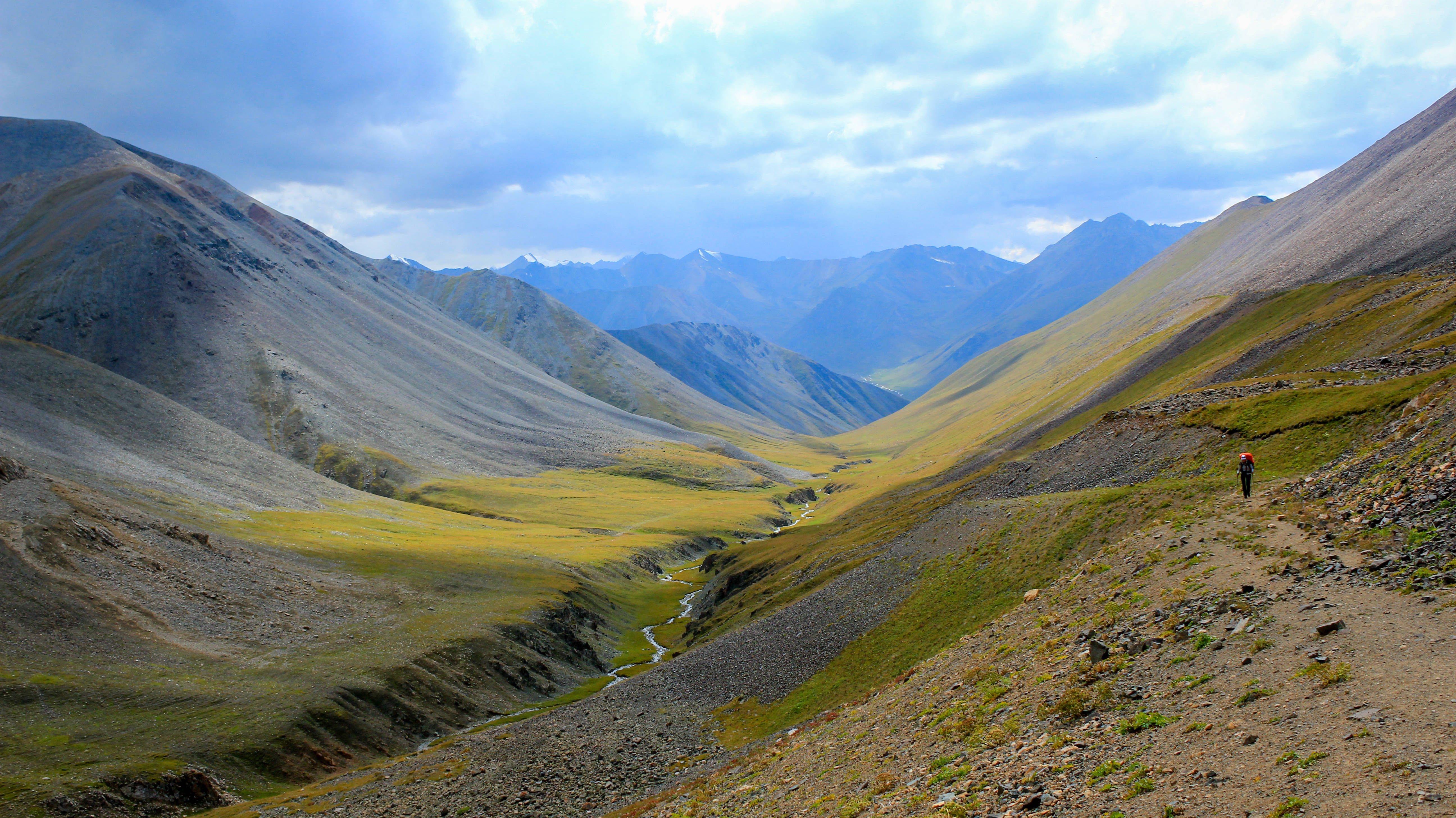 Kyrgyzstan, brown and green mountains, lone hiker in red, 5K Desktop Wallpaper