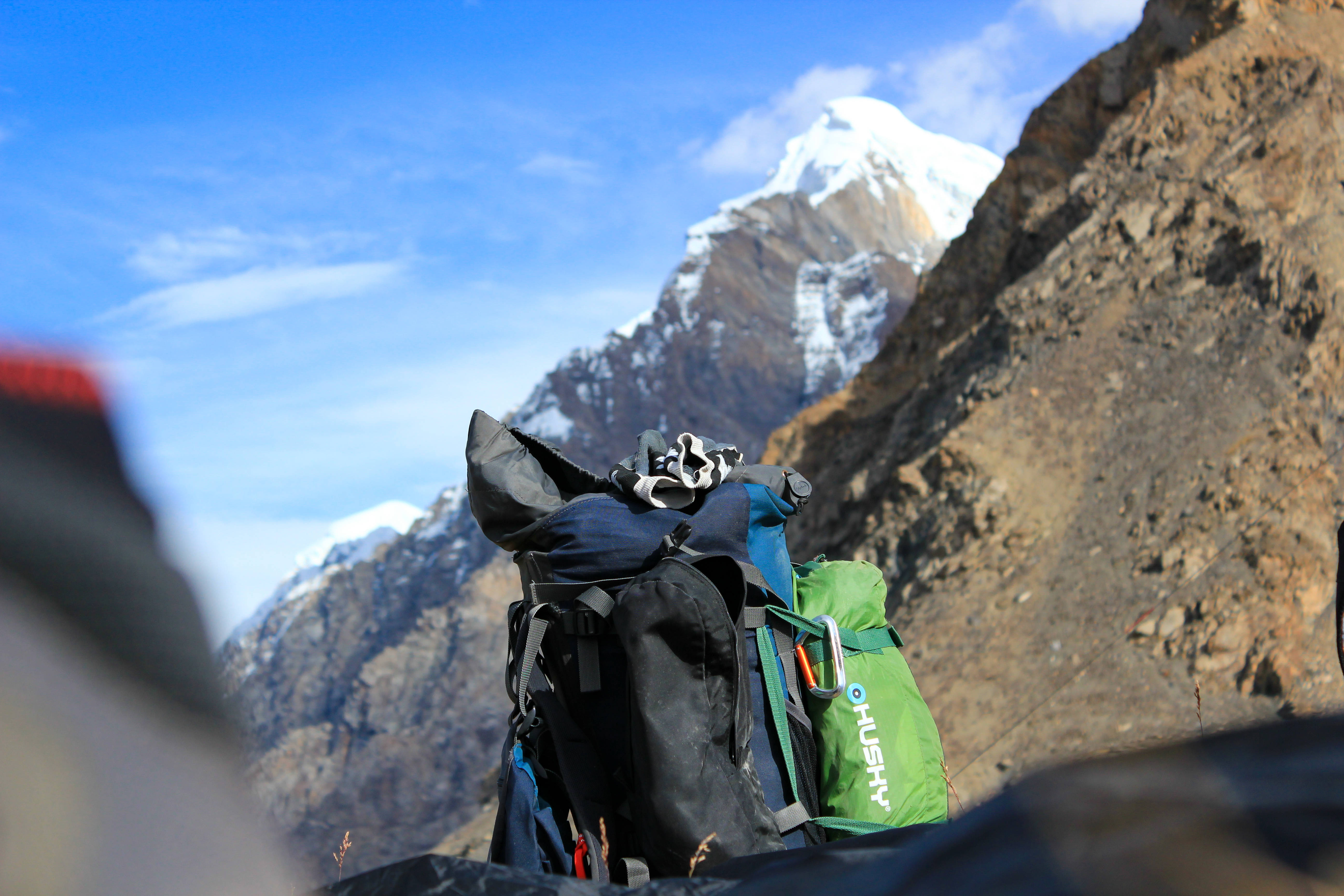 hiking backpack, rocky slope, snow-capped mountain peak, 5K Desktop Wallpaper