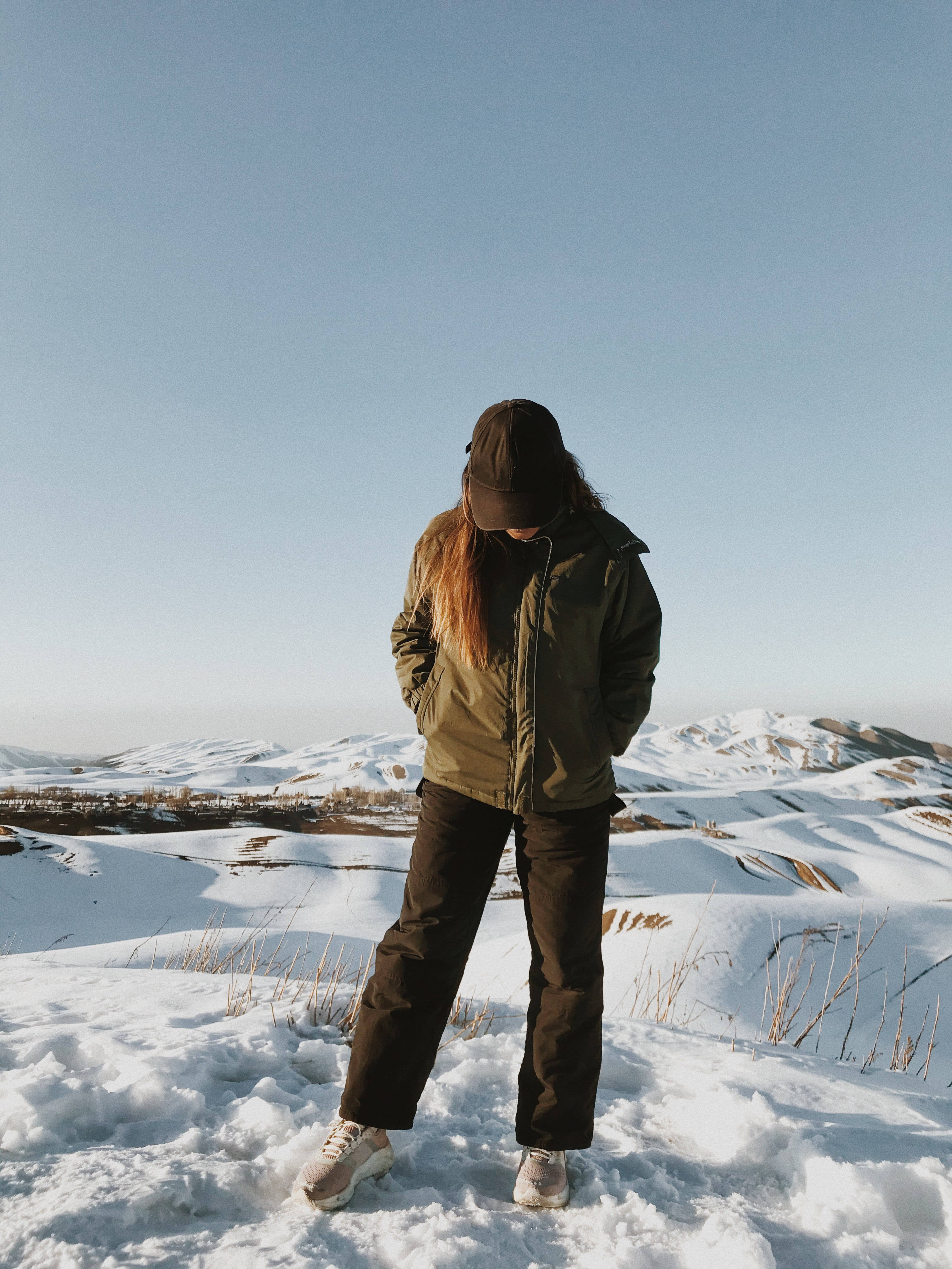 snow-covered hillside, clear blue sky, distant snow-capped mountains, 4K Phone Wallpaper