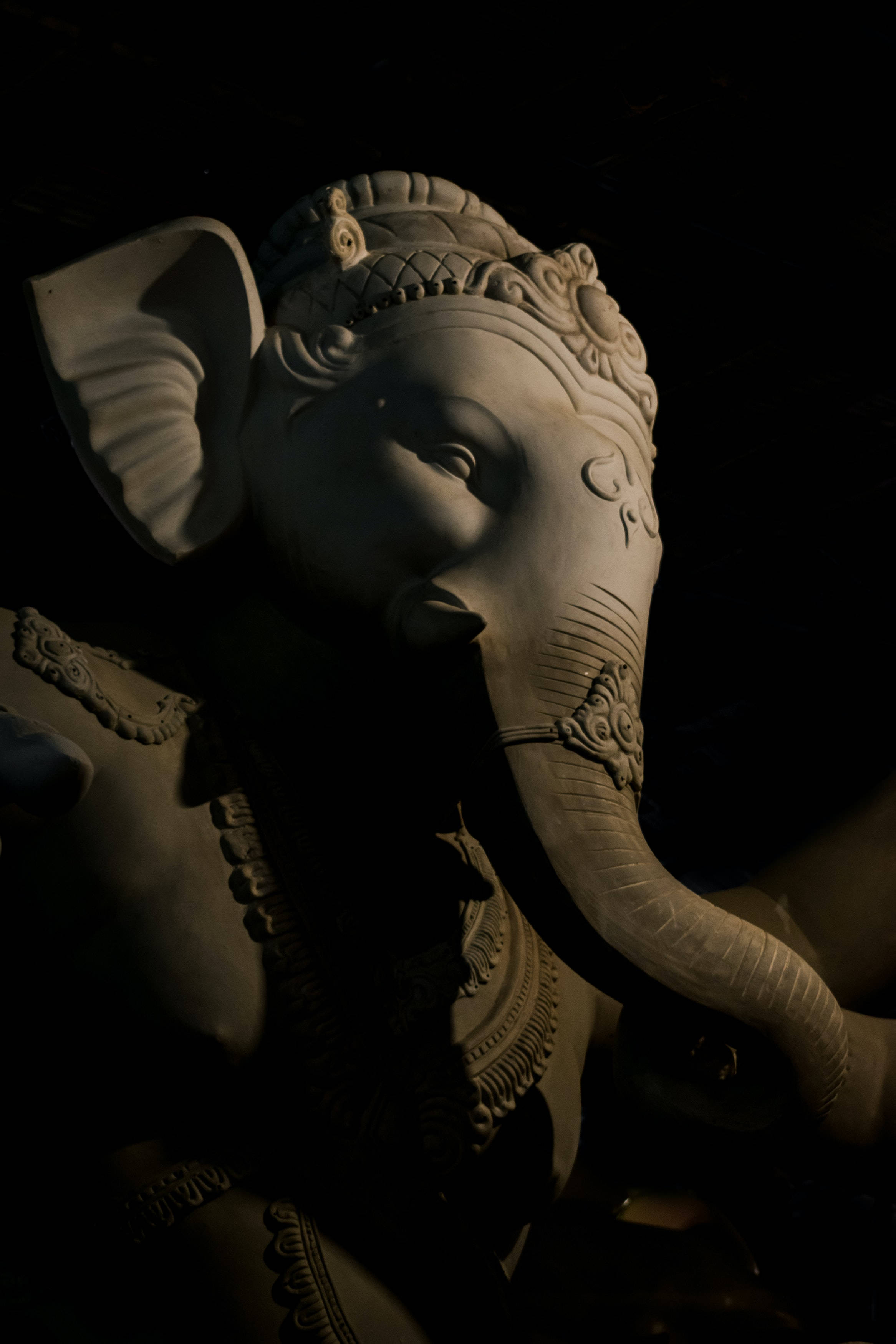 Lalbaugcha Raja, stone Ganesha statue, focused light, 2K Phone Wallpaper