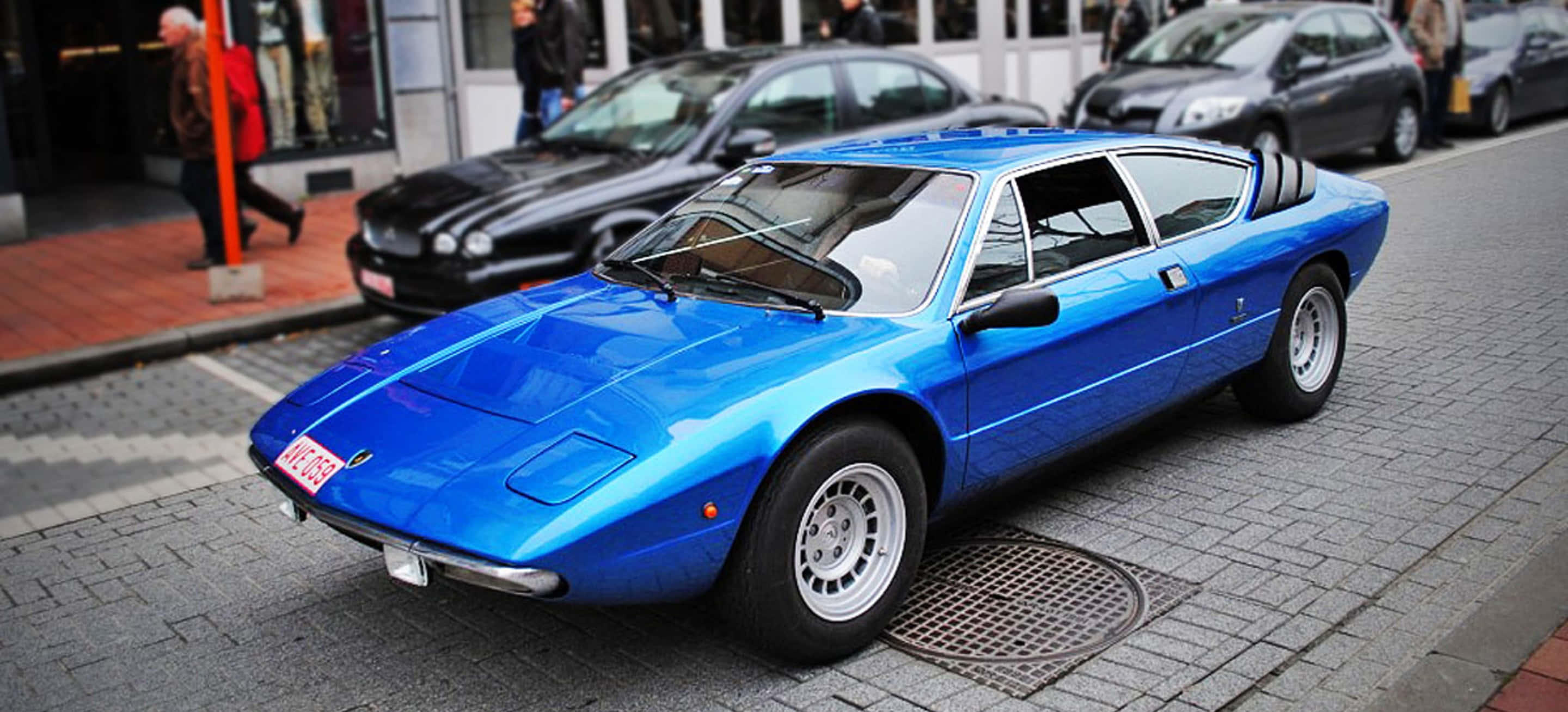 Lamborghini Urraco, vibrant blue, cobblestone street, 2K Desktop Wallpaper