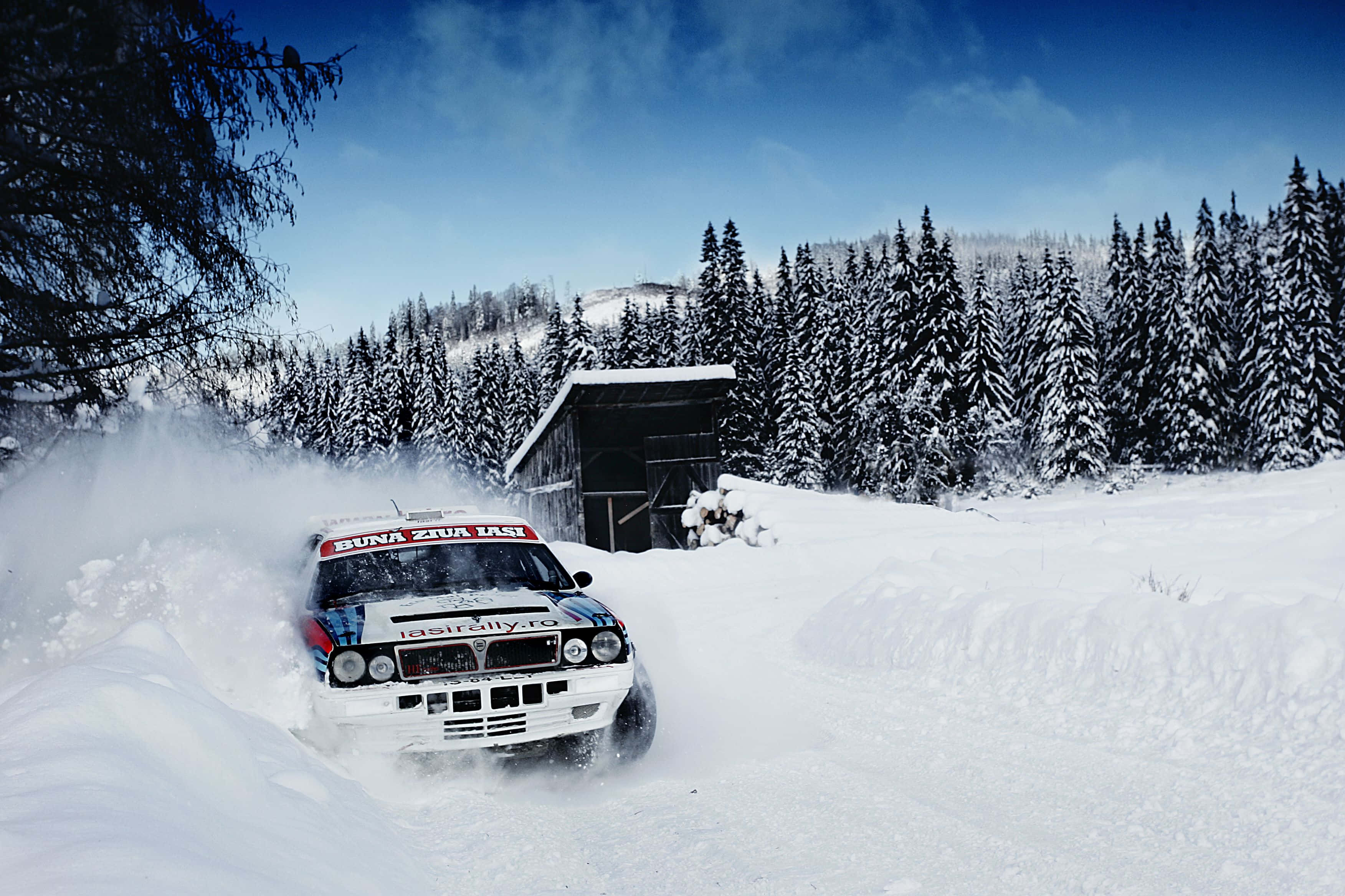 Lancia Delta, white rally car, snowy forested mountain pass, 2K Desktop Wallpaper