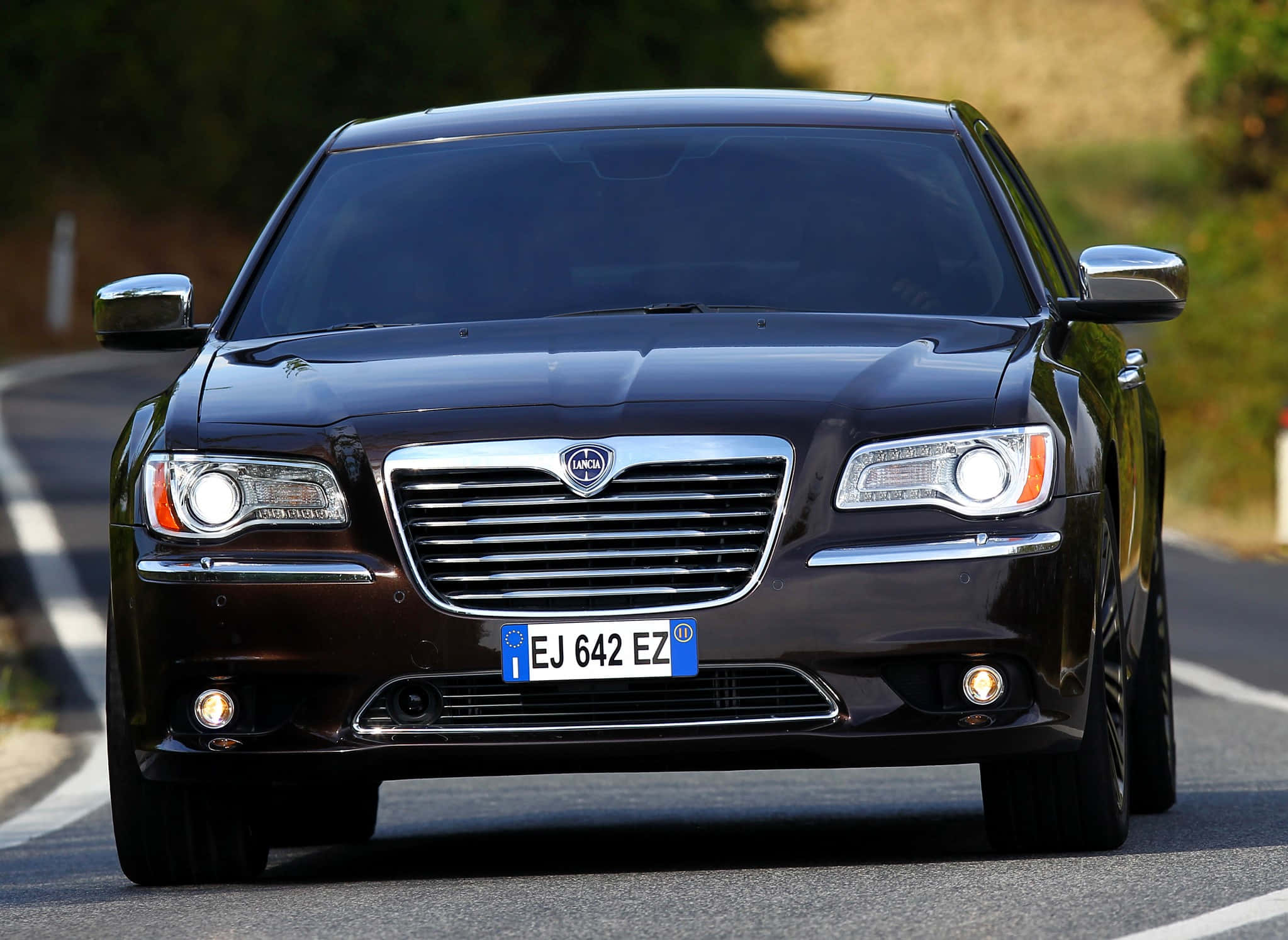 Lancia Thema, sleek black luxury sedan, sunlit rural road, Full HD Desktop Wallpaper