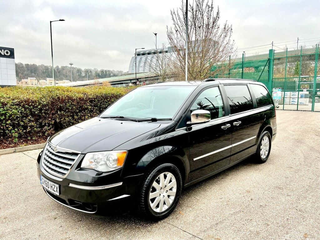 Lancia Voyager, sleek black minivan, gravel lot, SD Desktop Wallpaper