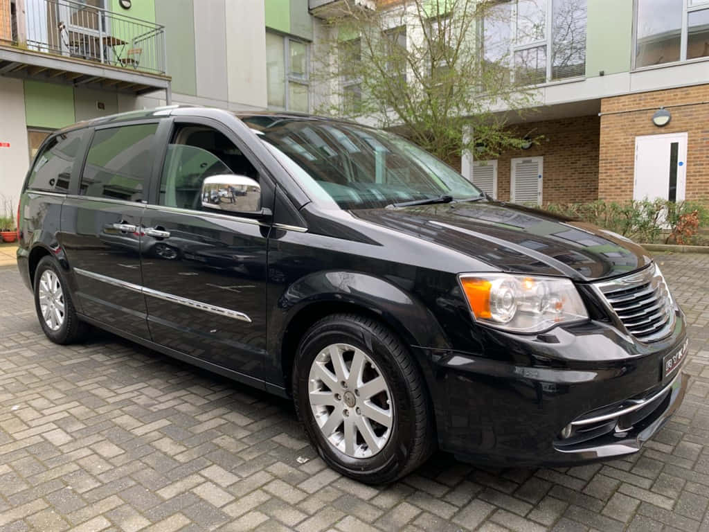 Lancia Voyager, sleek black minivan, gray brick driveway, SD Desktop Wallpaper